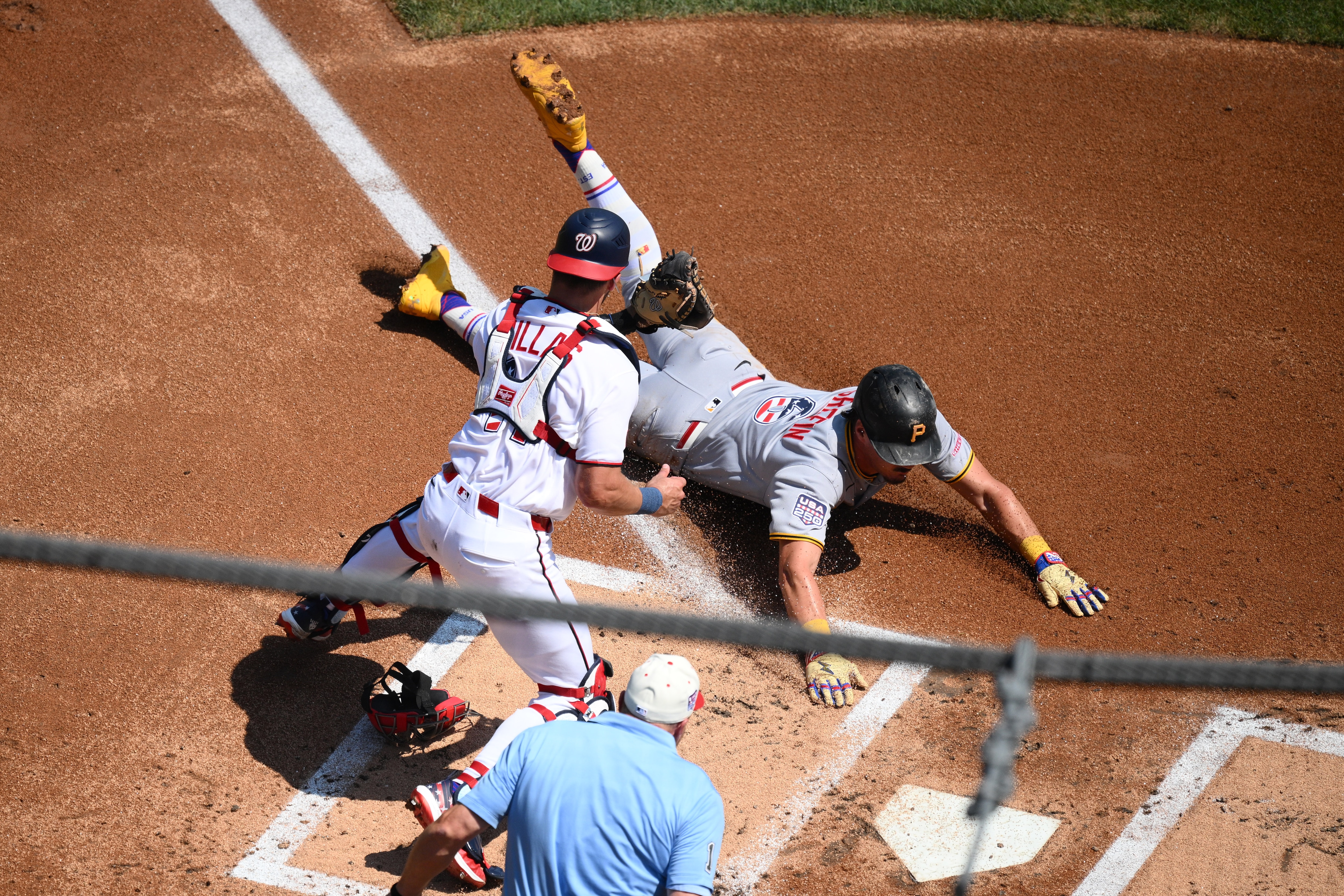Pittsburgh Pirates' Konnor Griffin, right, steals home to score against Washington Nationals catcher Drew Millas, left, during the first inning.
