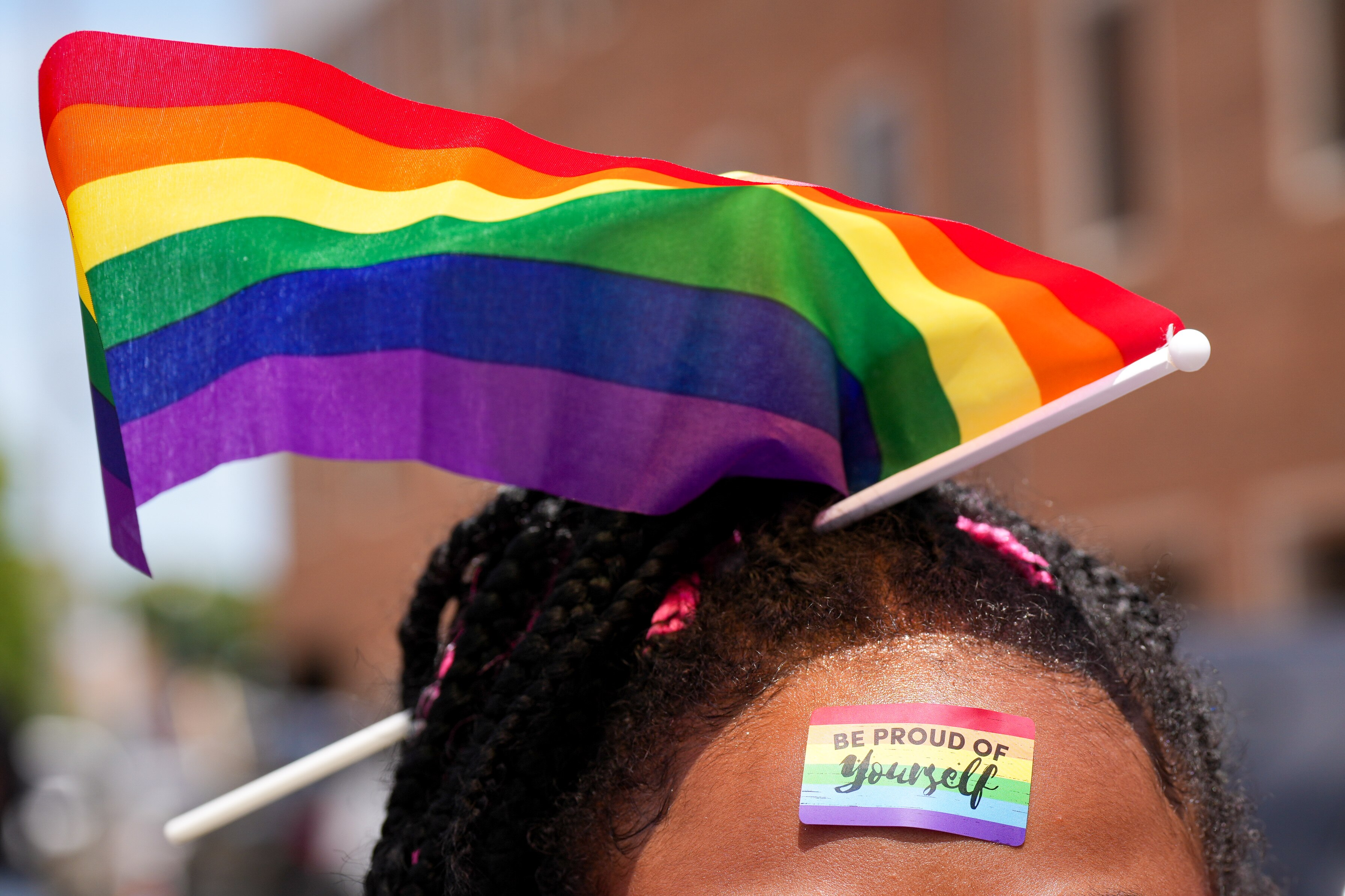 A young girl is seen with a rainbow sticker on her forehead and a flag in her hair along West St. during the Annapolis Pride Parade and Festival on June 1, 2024.