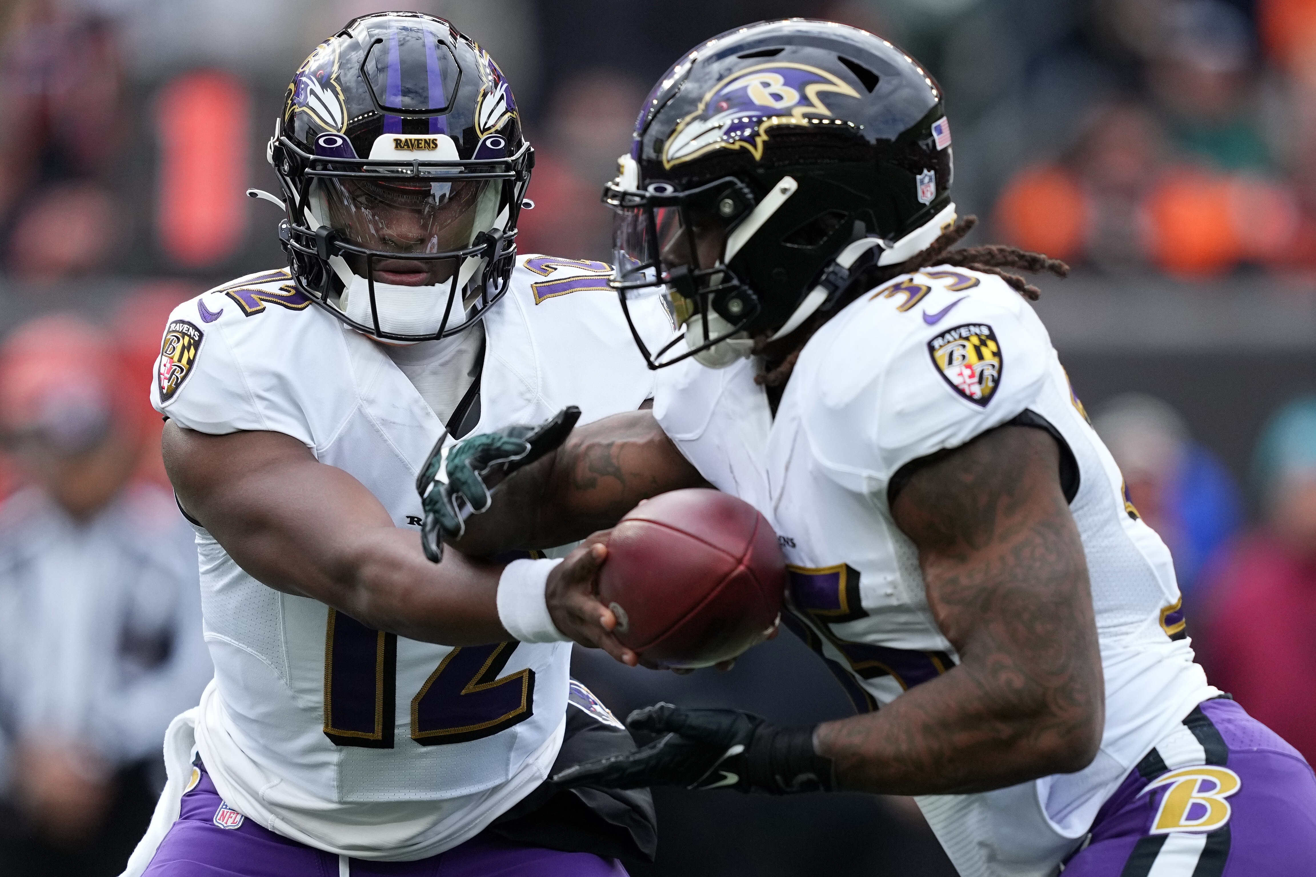 CINCINNATI, OHIO - JANUARY 08: Anthony Brown #12 of the Baltimore Ravens hands the ball to Gus Edwards #35 during the first quarter at Paycor Stadium on January 08, 2023 in Cincinnati, Ohio. (Photo by Dylan Buell/Getty Images)