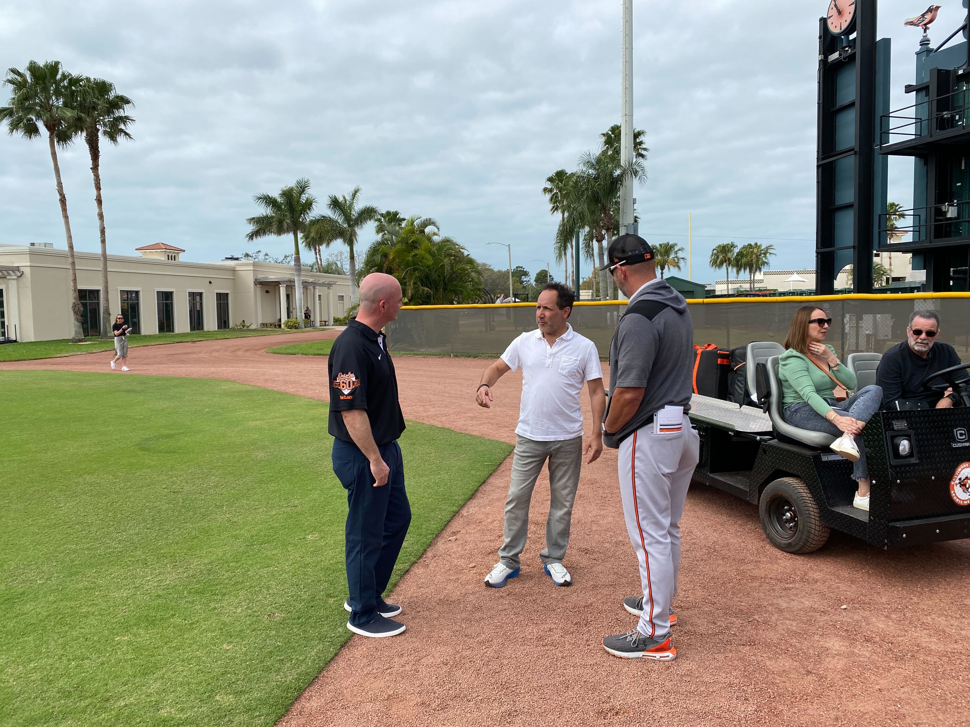 Orioles chairman and CEO John Angelos stops to chat with Dr. Derek Papp and manager Brandon Hyde during a visit to the team's spring training facility in Sarasota, Fla. (Andy Kostka/The Baltimore Banner)
