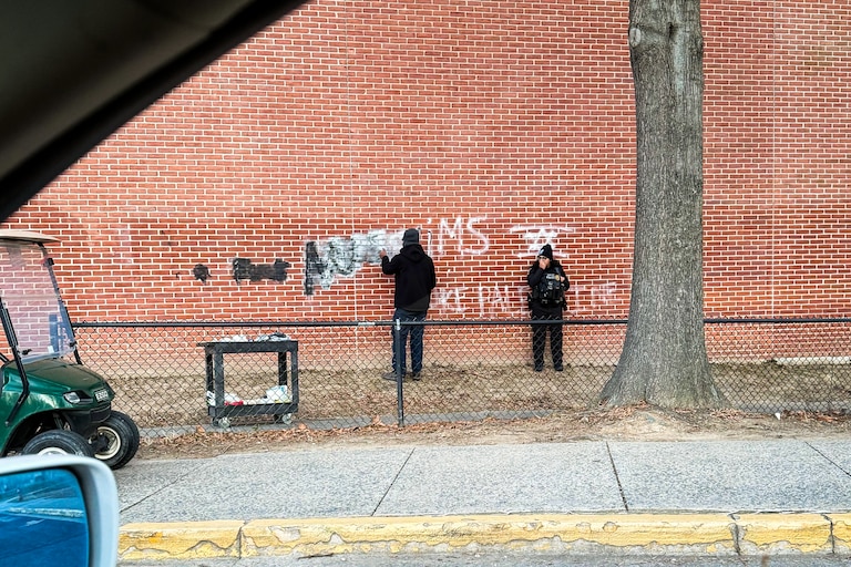 A neighbor driving by photographed anti-Muslim and anti-Palestinian graffiti being cleaned off a wall at Walt Whitman High School in Bethesda on Friday.