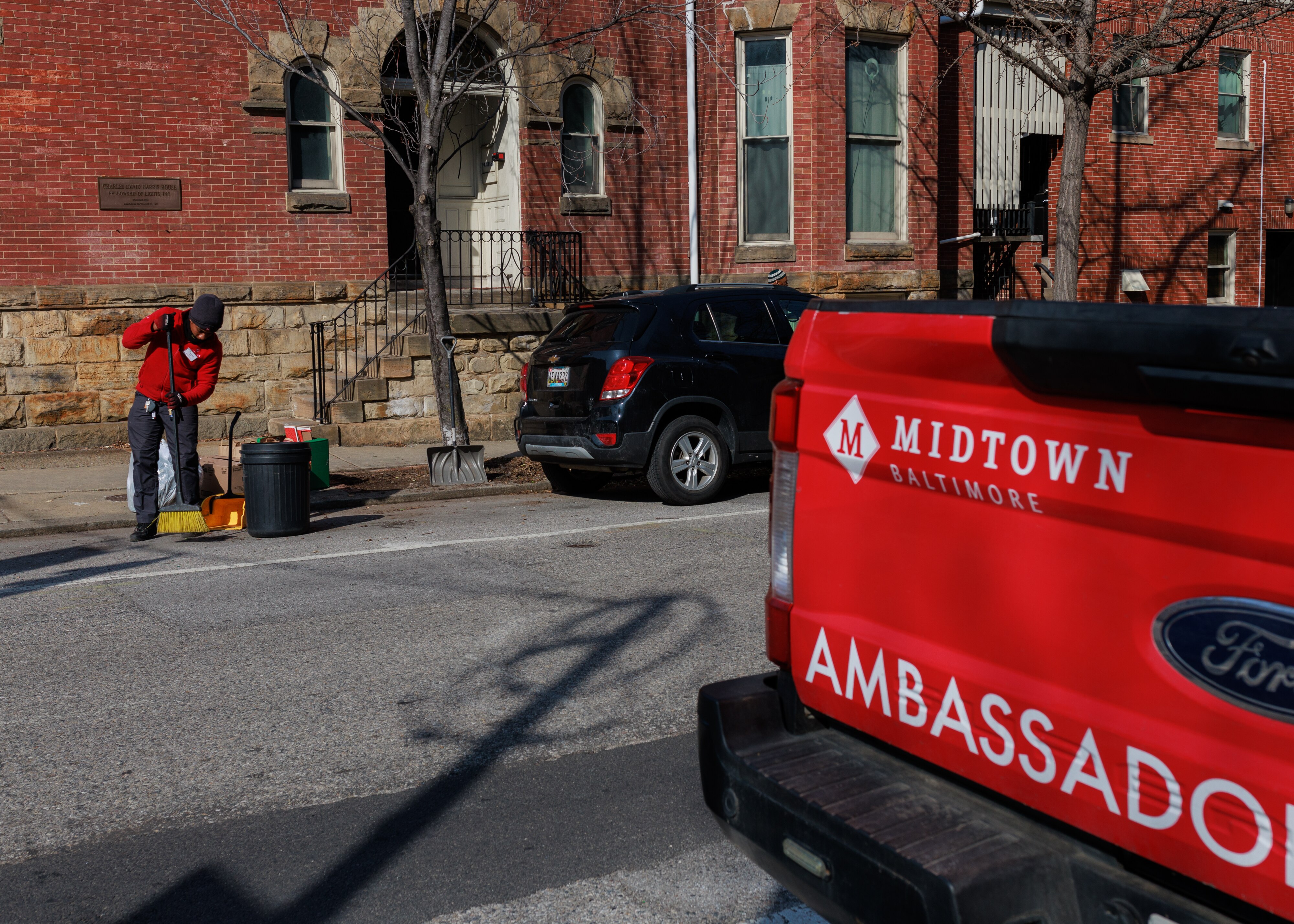 Jalen Blackston, a Midtown Community Benefits District crew member, sweeps a street in the Mount Vernon neighborhood of Baltimore.