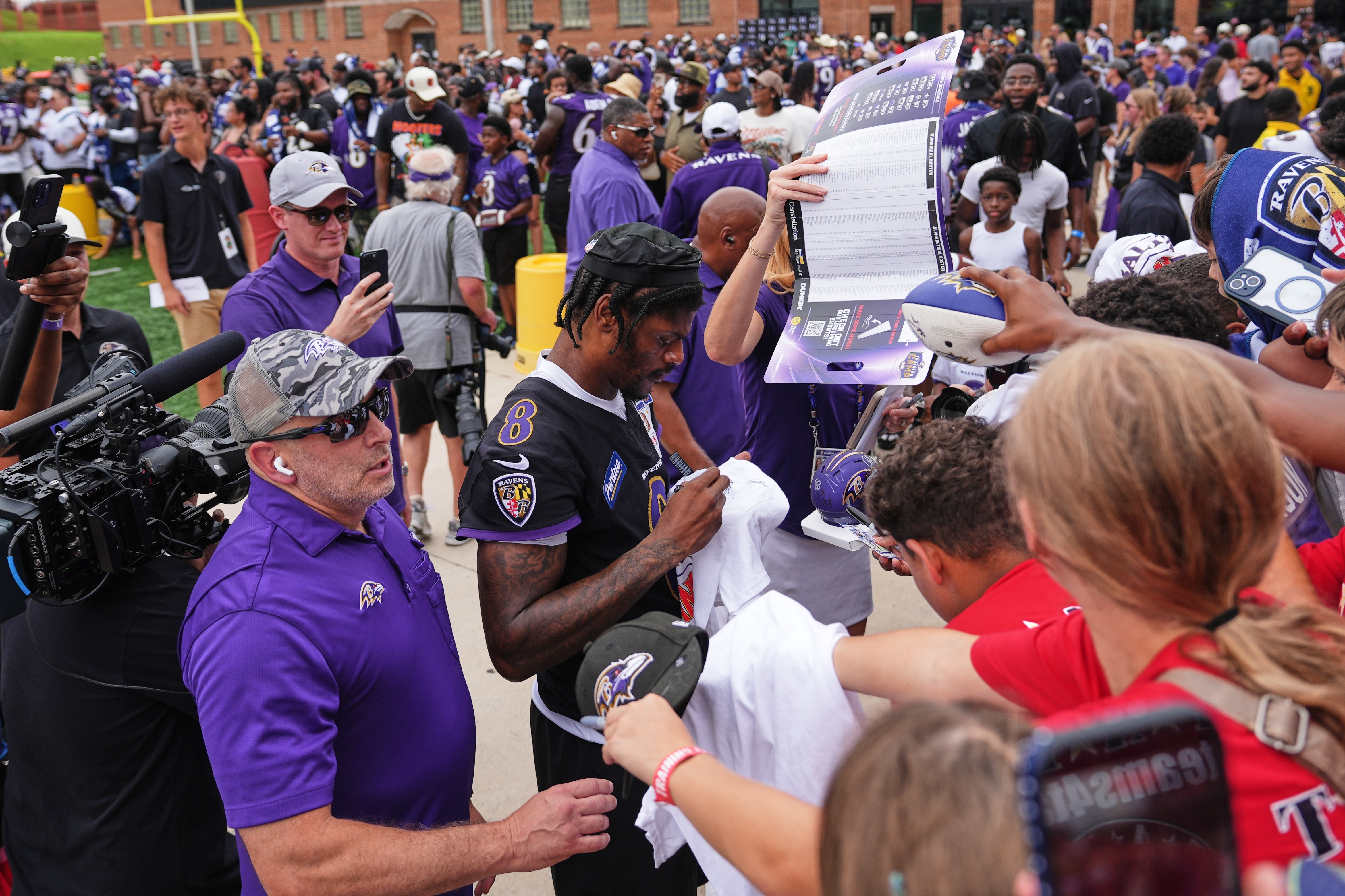 Baltimore Ravens quarterback Lamar Jackson (8) signs autographs for fans during the team's NFL football training camp at the University of Maryland in College Park, Md., Saturday, Aug. 1, 2026. (AP Photo/Stephanie Scarbrough)