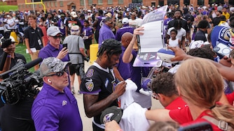 Baltimore Ravens quarterback Lamar Jackson (8) signs autographs for fans during the team's NFL football training camp at the University of Maryland in College Park, Md., Saturday, Aug. 1, 2026. (AP Photo/Stephanie Scarbrough)