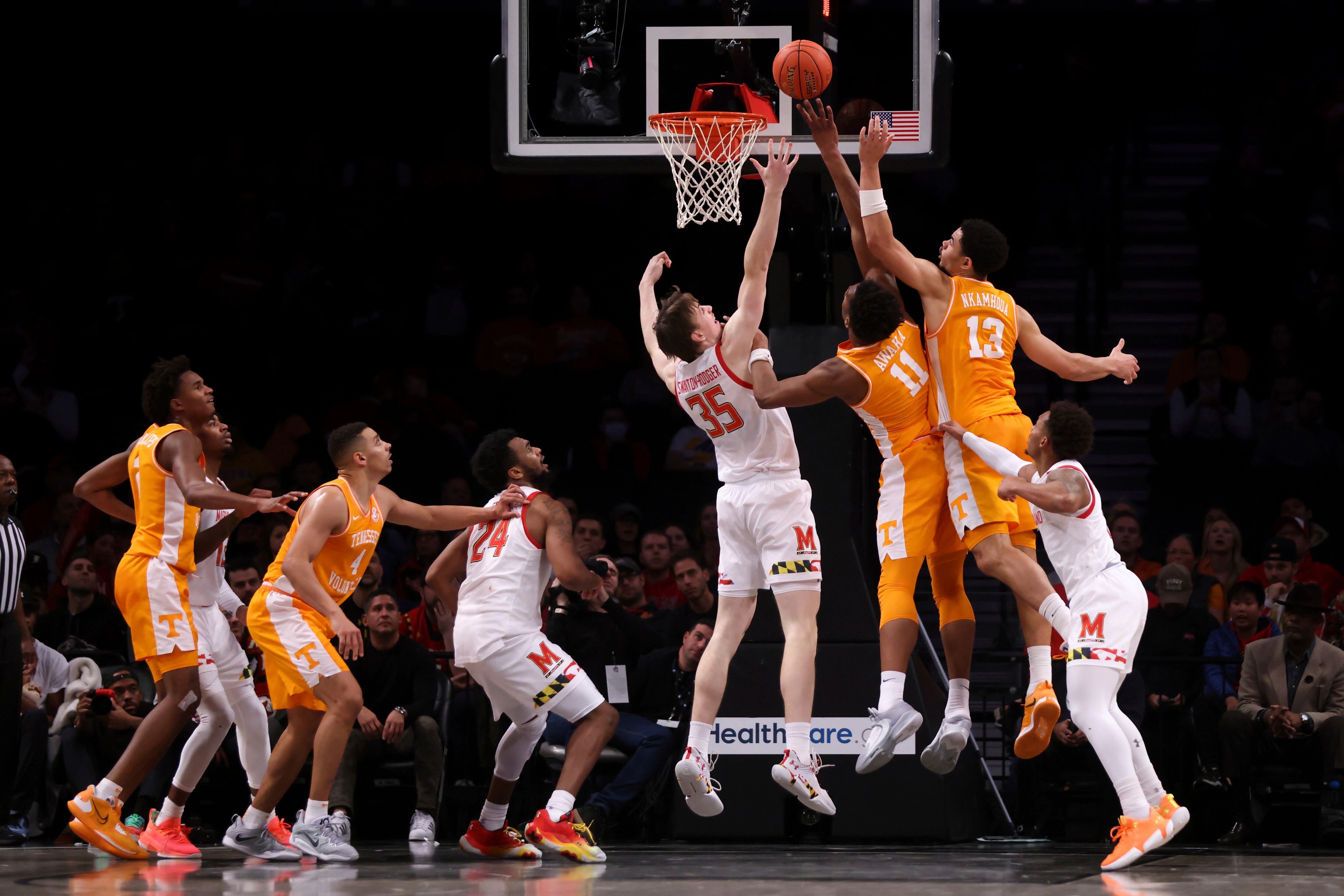Maryland center Caelum Swanton-Rodger (35), Tennessee forward Tobe Awaka (11) and Tennessee forward Olivier Nkamhoua (13) jump for the ball during the first half of an NCAA college basketball game in the Basketball Hall of Fame Invitational, Sunday, Dec. 11, 2022, in New York. (AP Photo/Julia Nikhinson)