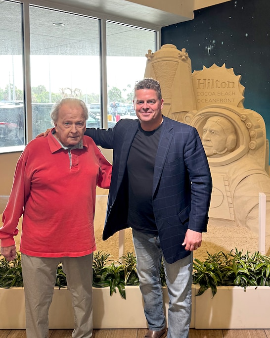 Bill Wiseman IV, left, and his older son, also named Bill, pose for a photo in front of an astronaut sand sculpture after arriving in Florida to see liftoff of Artemis II, led by Reid Wiseman.