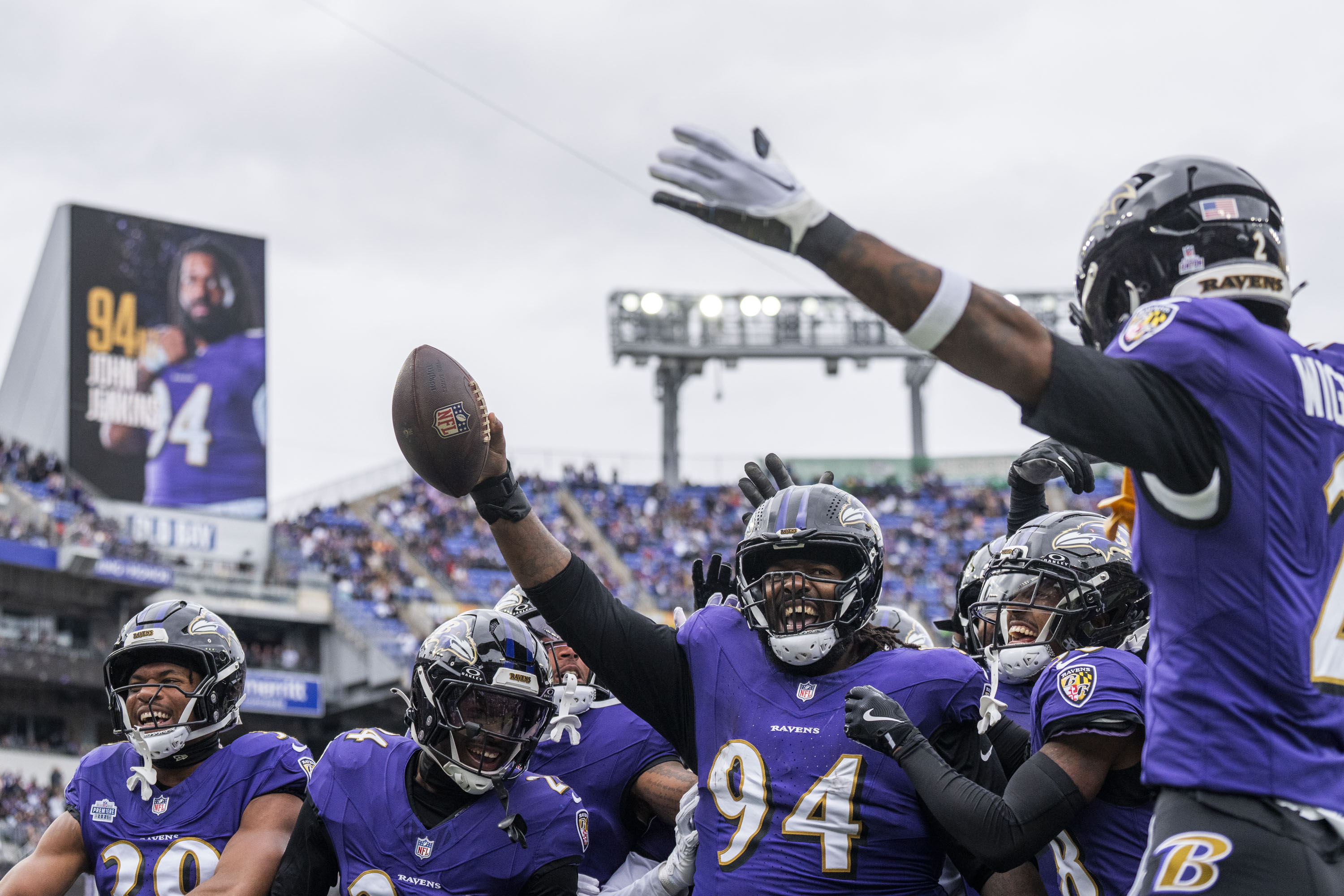Ravens nose tackle John Jenkins, center, holds up a football and cheers during the first quarter at M&T Bank Stadium on October 12, 2025.