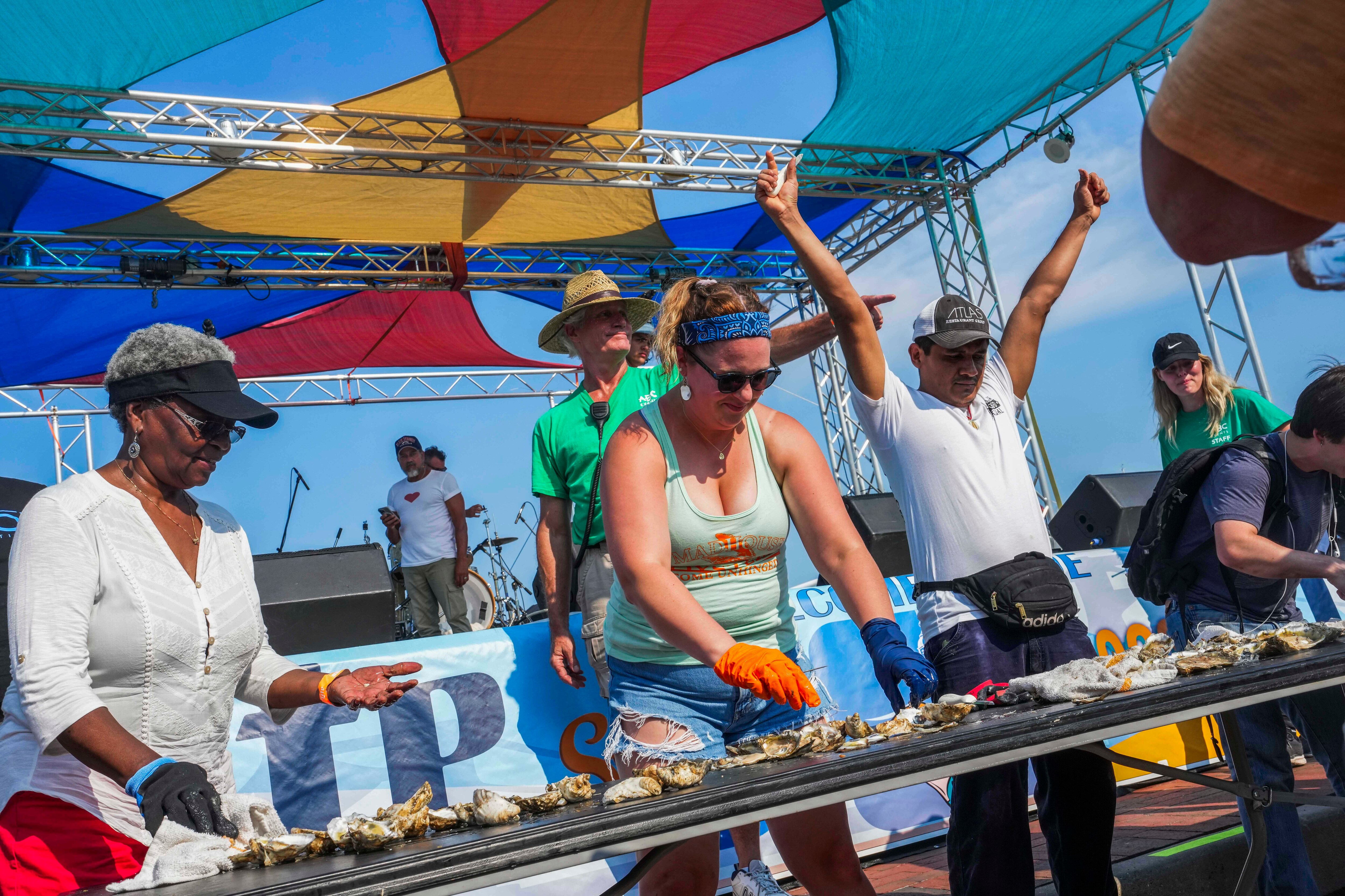 People participate in the oyster shucking contest at the Maryland Seafood Festival in Annapolis on August 20, 2023. They had three minutes to shuck as many as they could.