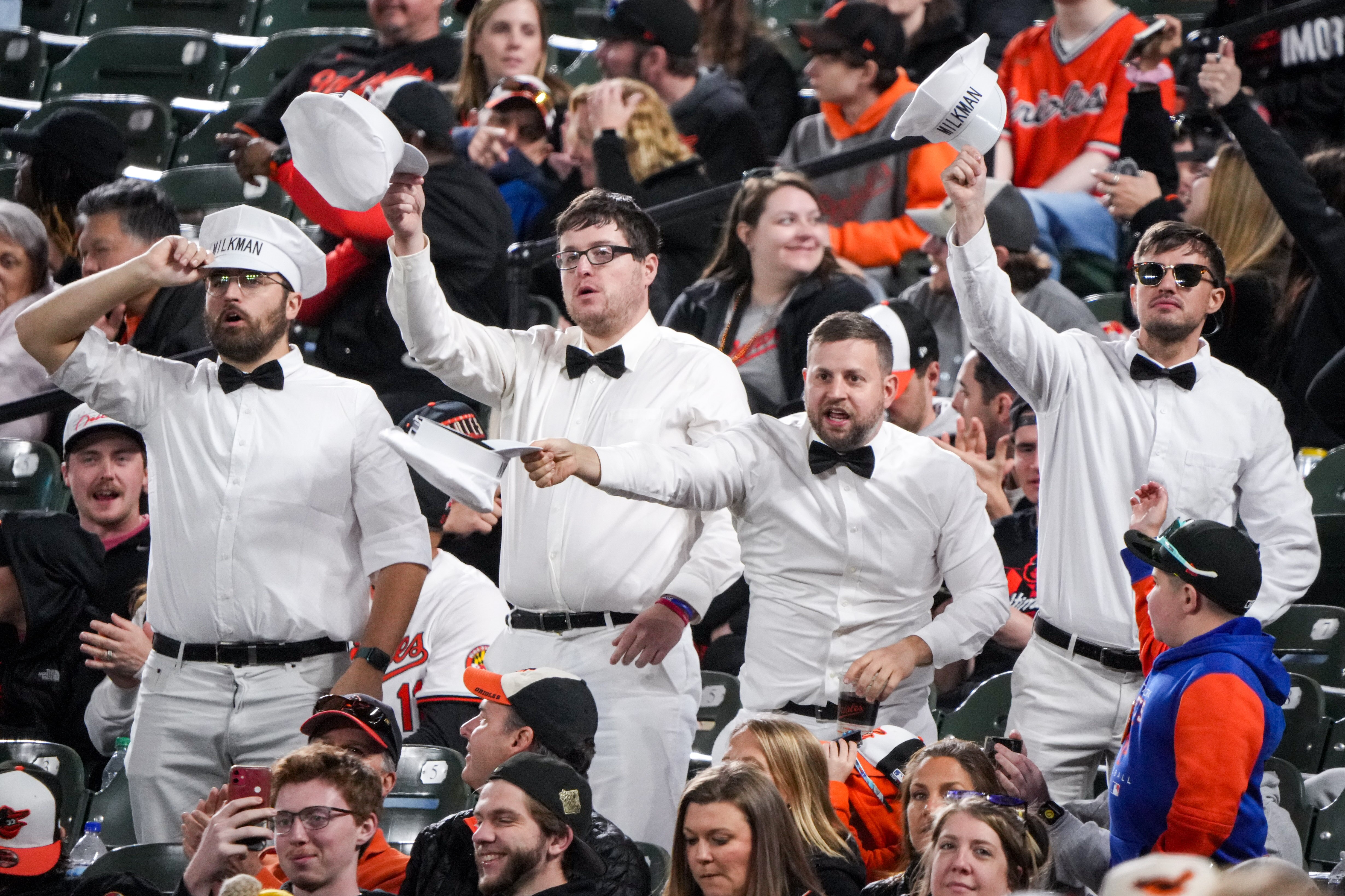 Orioles fans dressed as milkmen wave their caps and "MOOOO" in support of outfielder Colton Cowser during a game against the Oakland Athletics on April 26, 2024.