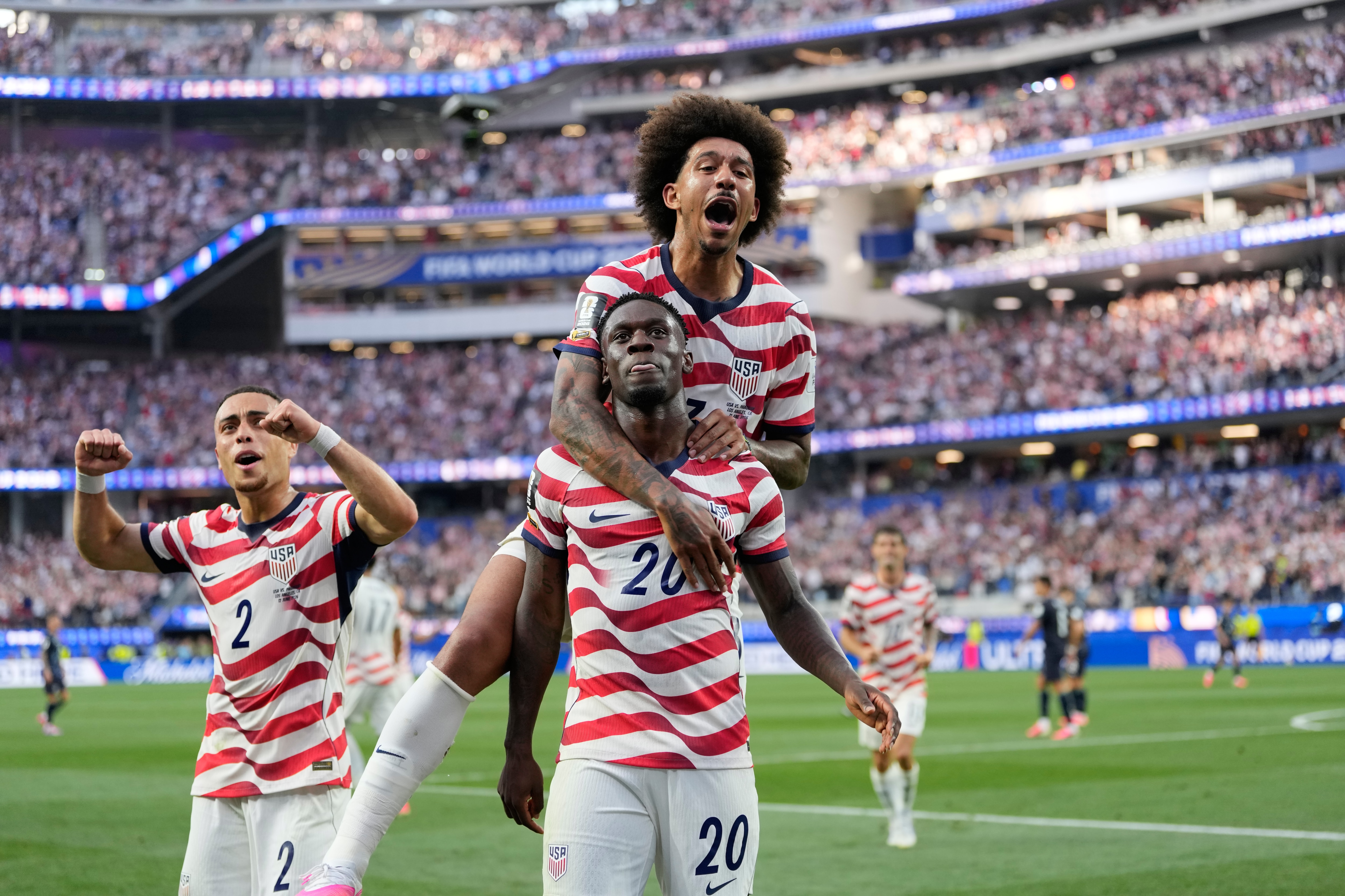 United States' Folarin Balogun (20) celebrates scoring his side's third goal against Paraguay with teamates during the World Cup Group D soccer match in Inglewood, Calif., near Los Angeles, Friday, June 12, 2026. (AP Photo/Andre Penner)