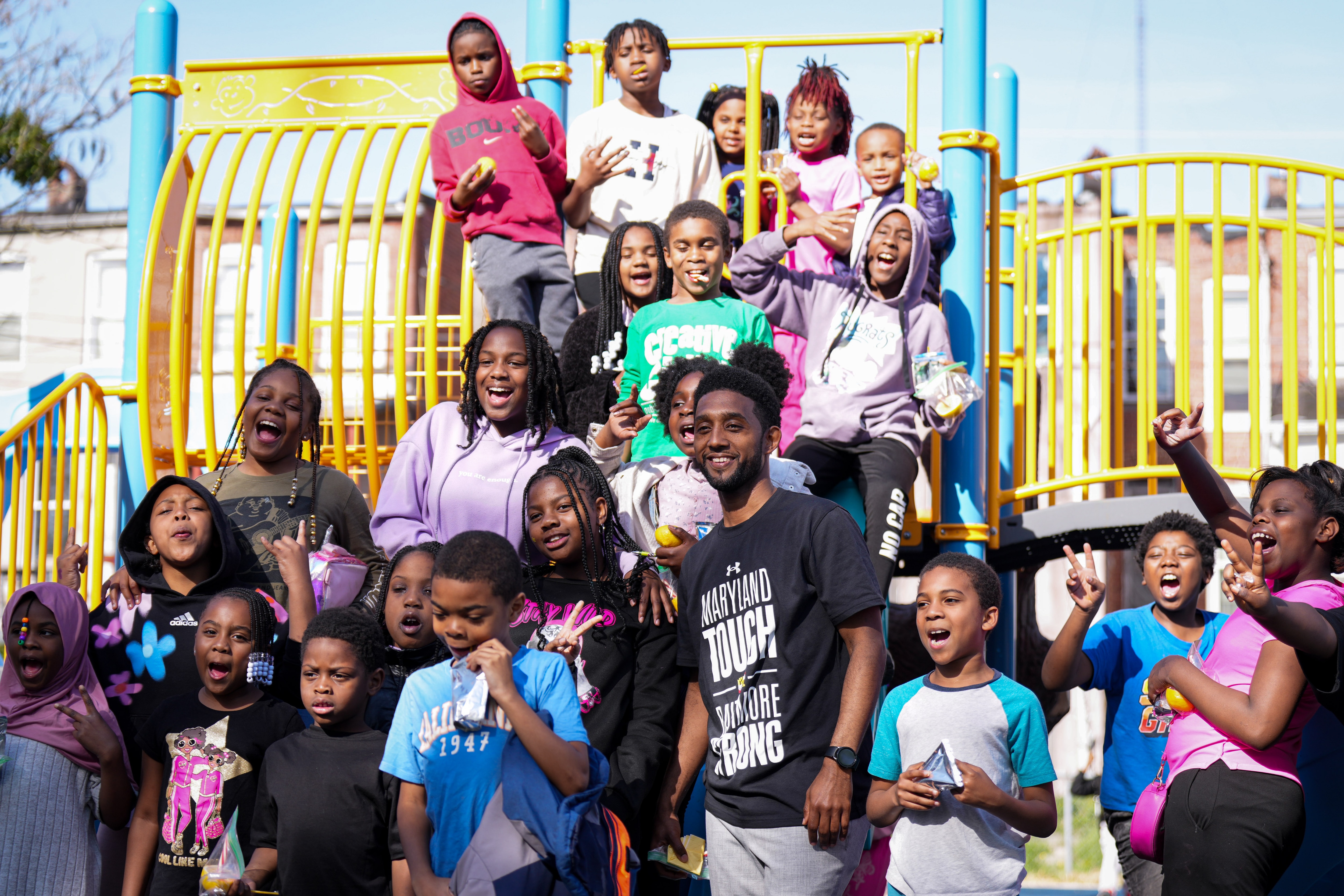 Baltimore Mayor Brandon Scott (middle) poses for a photo with children from Towanda Recreation Center at the opening of Candy Stripe Park Playground in the city's Park Heights neighborhood on Tuesday.
