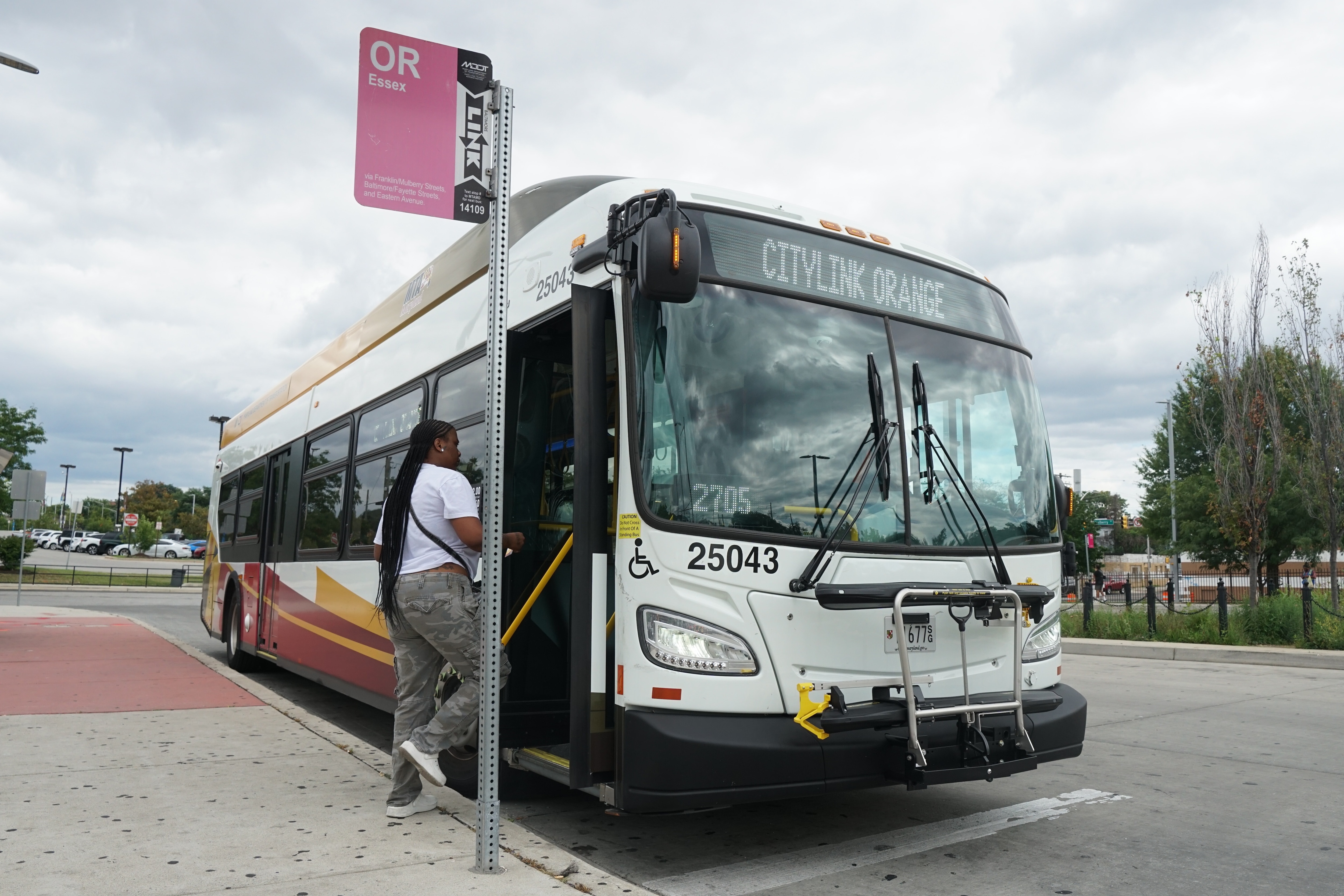 July 29, 2026 - A woman boards the Maryland Transit Administration CityLink Orange at the West Baltimore MARC Station. A new MTA project breaking ground this month aims to speed up crosstown bus routes like the Orange.
