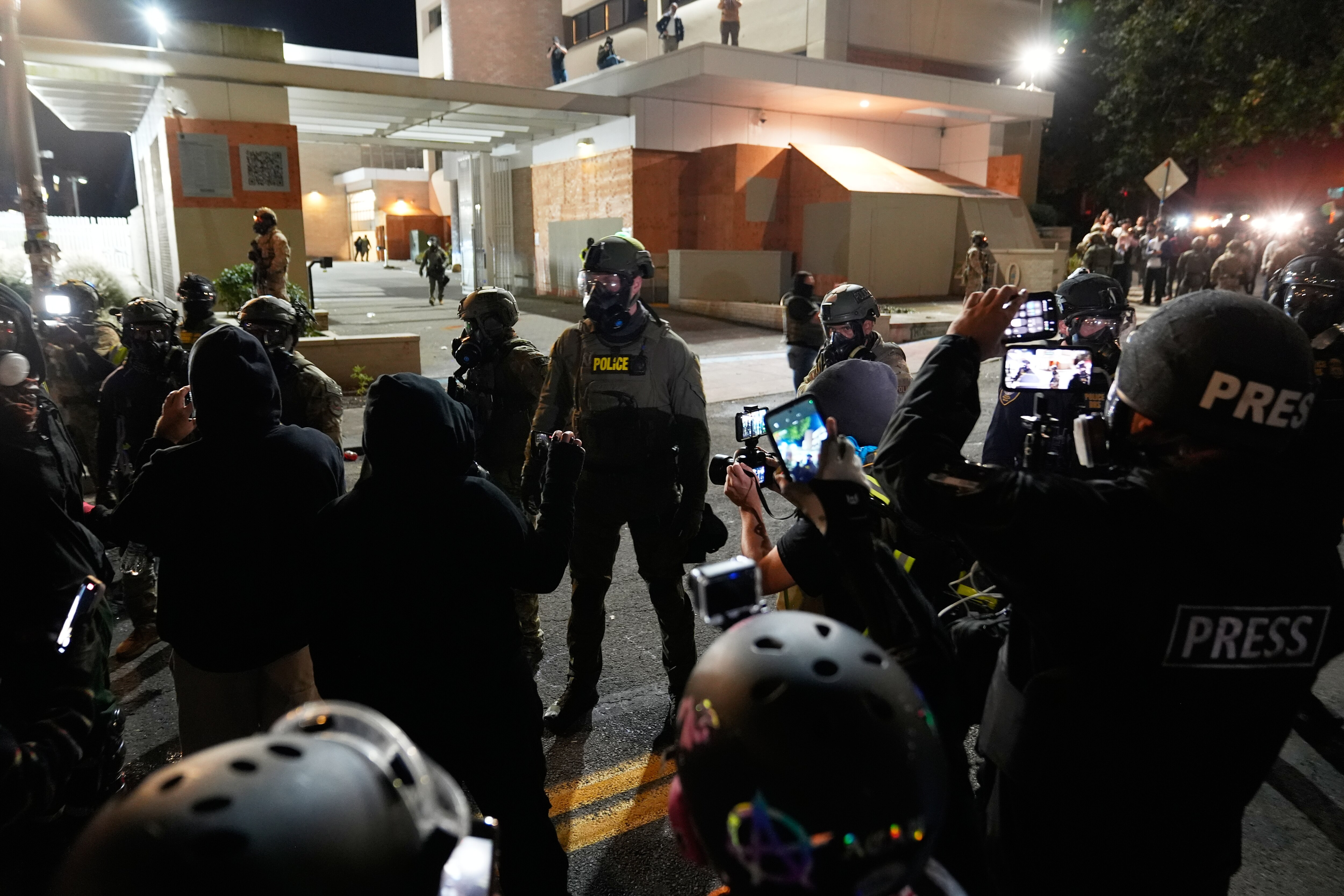 Law enforcement officers standoff against demonstrators outside a U.S. Immigration and Customs Enforcement facility during a protest on Saturday, Oct. 4, 2025, in Portland, Ore.