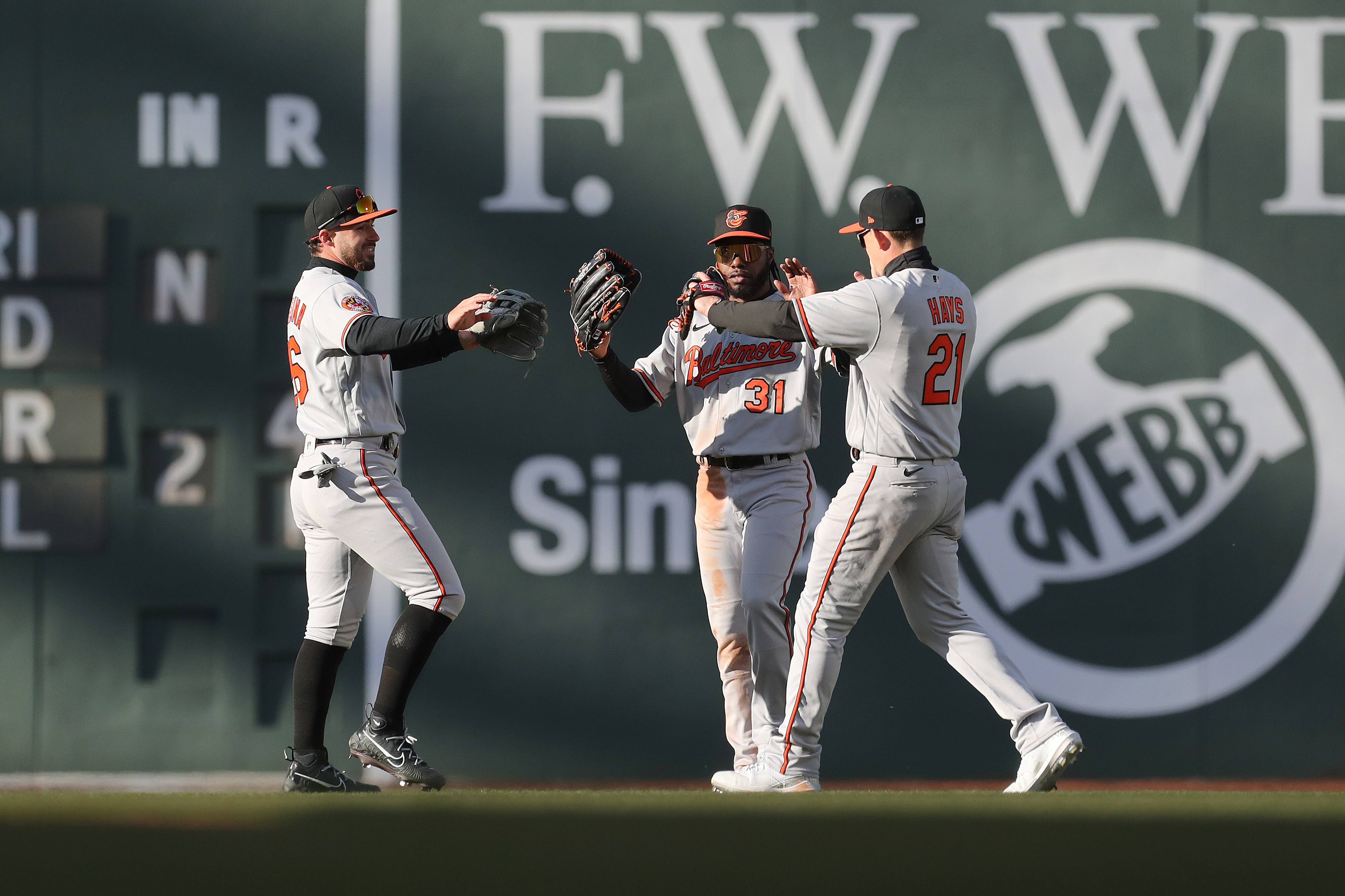 Austin Hays #21 and Ryan McKenna #26 and Cedric Mullins #31 of the Baltimore Orioles celebrate after defeating the Boston Red Sox on Opening Day at Fenway Park on March 30, 2023 in Boston, Massachusetts.