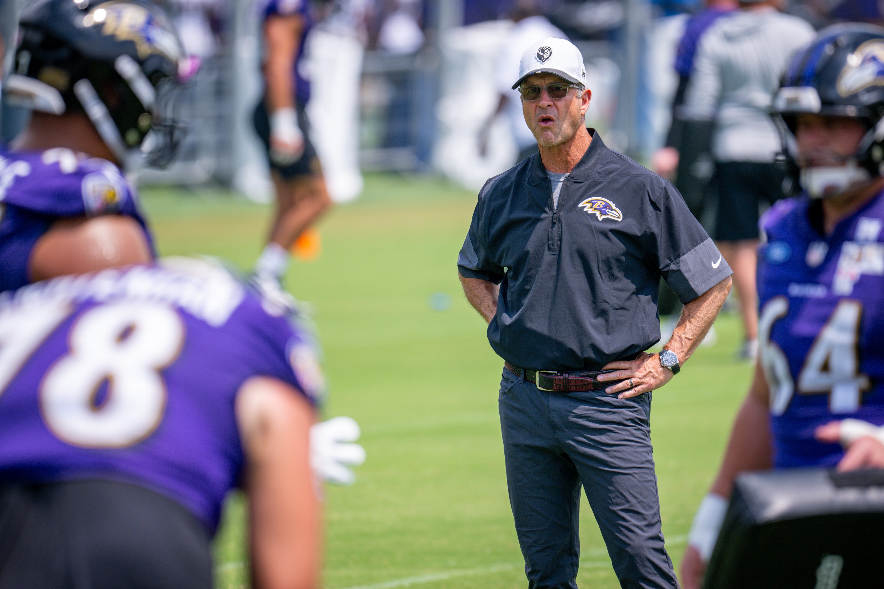 Ravens coach John Harbaugh watches the defensive line run through drills on July 31.