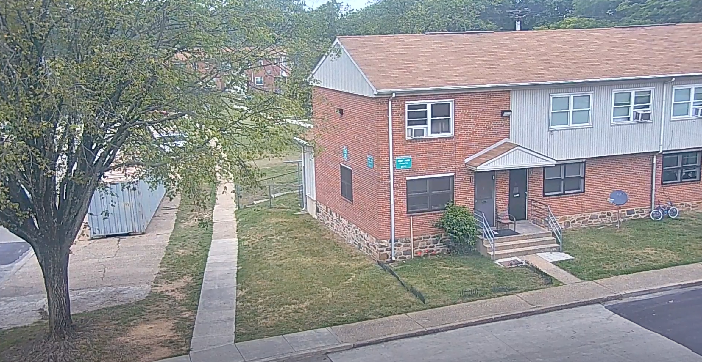 Footage from a Baltimore Police CitiWatch camera shows that a 45-foot elm tree obstructed the camera's view of the Brooklyn Homes mass shooting. This screenshot was taken from footage recorded the day before the block party. It was obtained by The Banner through a public records request. (CitiWatch footage from the Baltimore Police Department)
