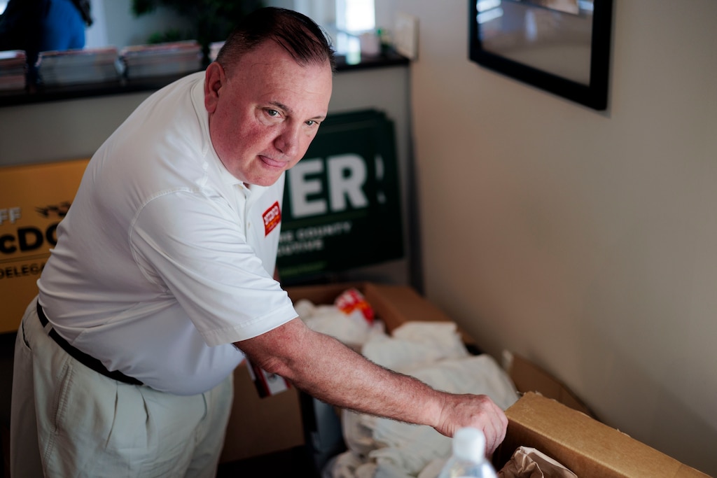 Nino Mangione’s campaign consultant Kelley Rogers organizes promotional t-shirts during an Early Voting Meet and Greet event at Brookside Market.
