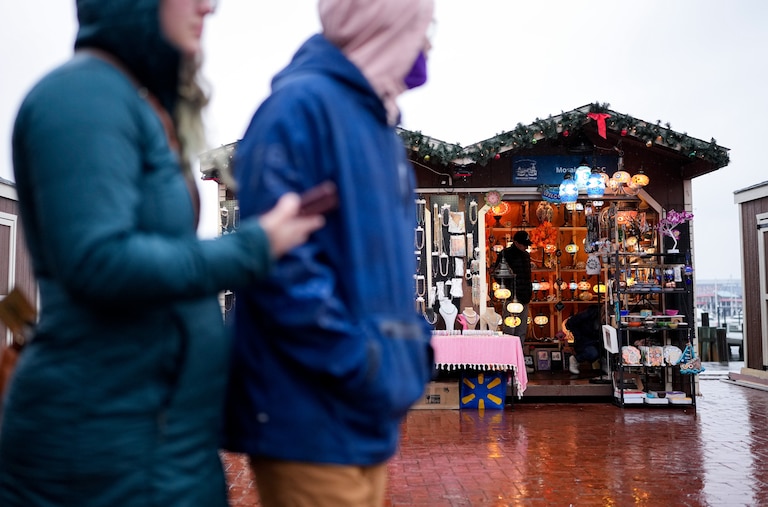 Patrons walk past vendors through the Christmas Village at the Inner Harbor in Baltimore, Md. on Friday, December 20, 2024.