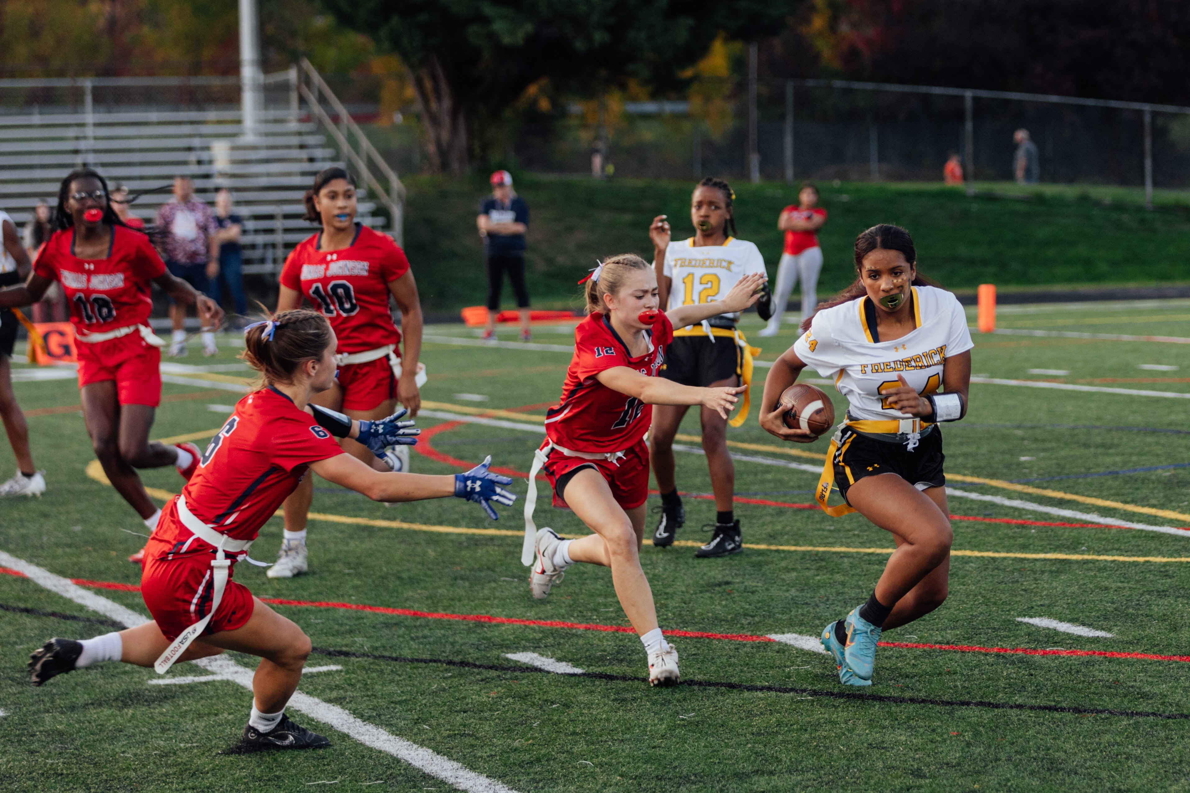 Frederick County Cadets freshman Maya Robinson runs the ball against the Thomas Johnson Patriots during the final minutes of regular season play in the girls varsity flag football season at Thomas Johnson High School, on Thursday, Oct. 26, 2023 in Frederick, MD. (Wesley Lapointe / for the Baltimore Banner)