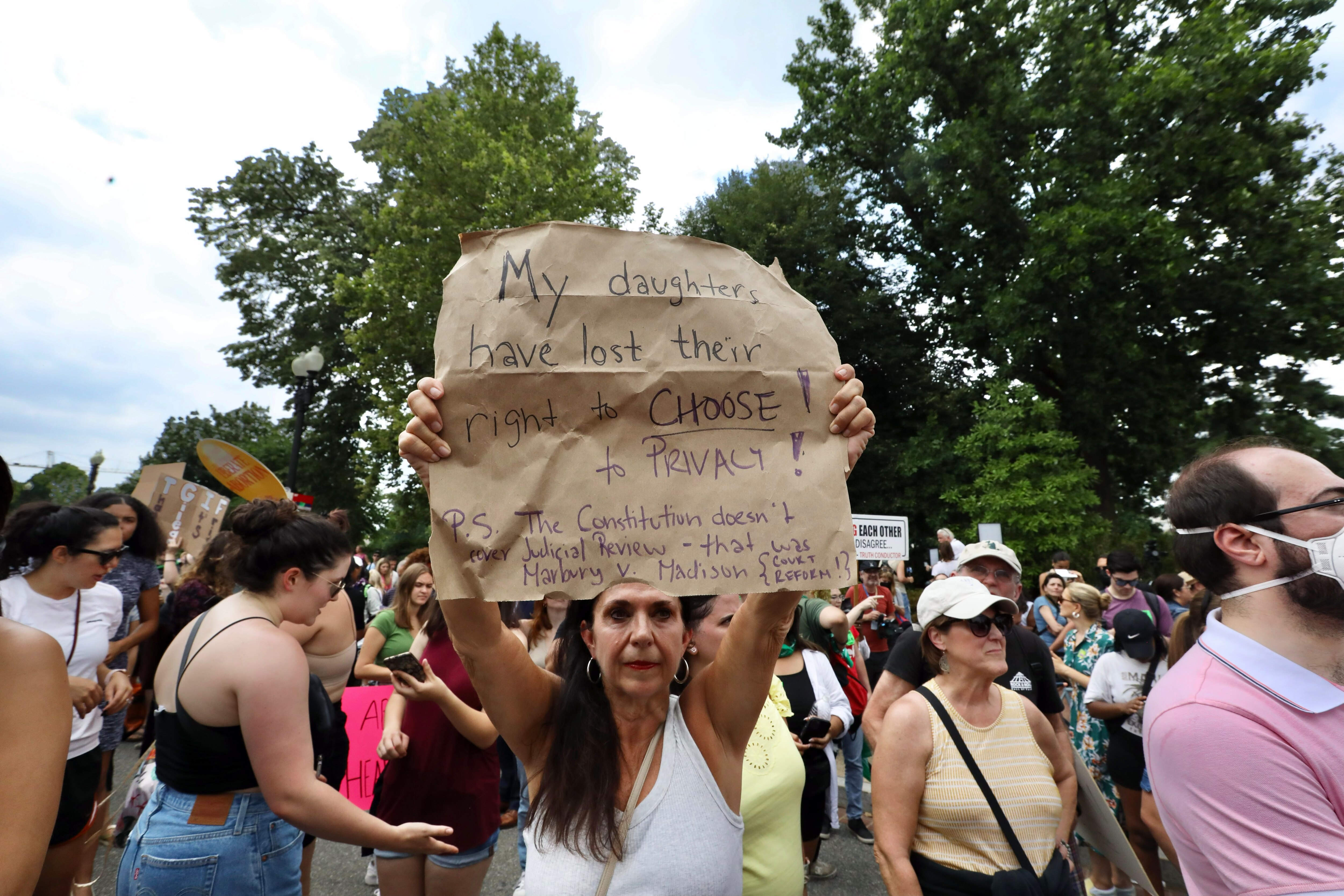 Liz Costanzo, 59, of Washington, D.C., holds up a sign during a protest after Roe v. Wade was overturned by the Supreme Court.