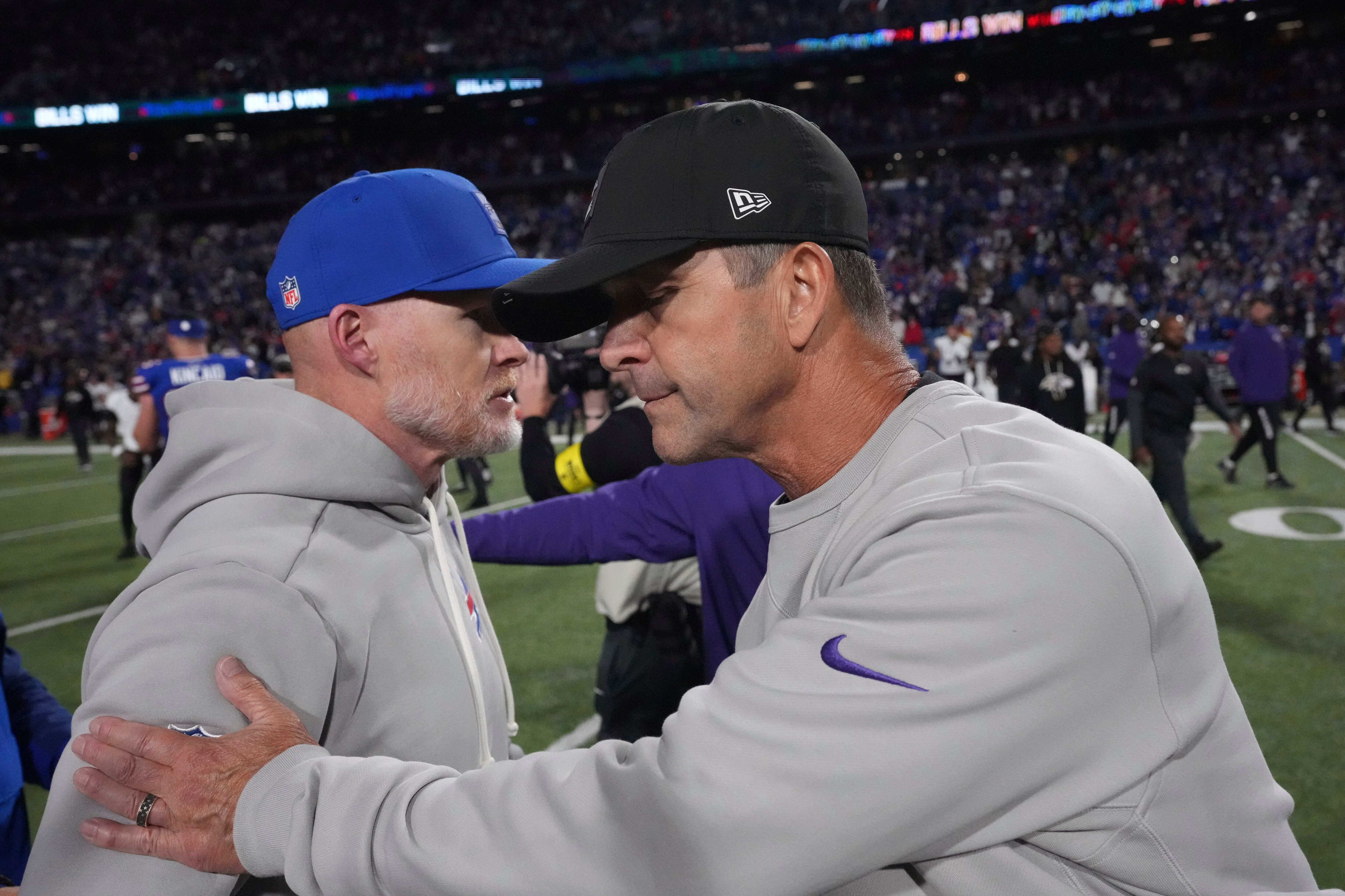 Buffalo Bill head coach Sean McDermott, left, and Baltimore Ravens head coach John Harbaugh, right, greet at midfield.