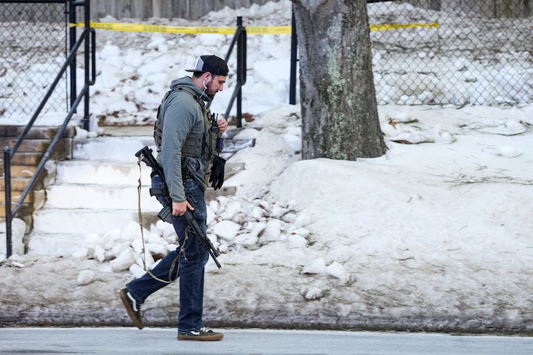 A Montgomery County Police officer walks past the barricaded Thomas S. Wootton High School after a reported shooting at the school on Monday.