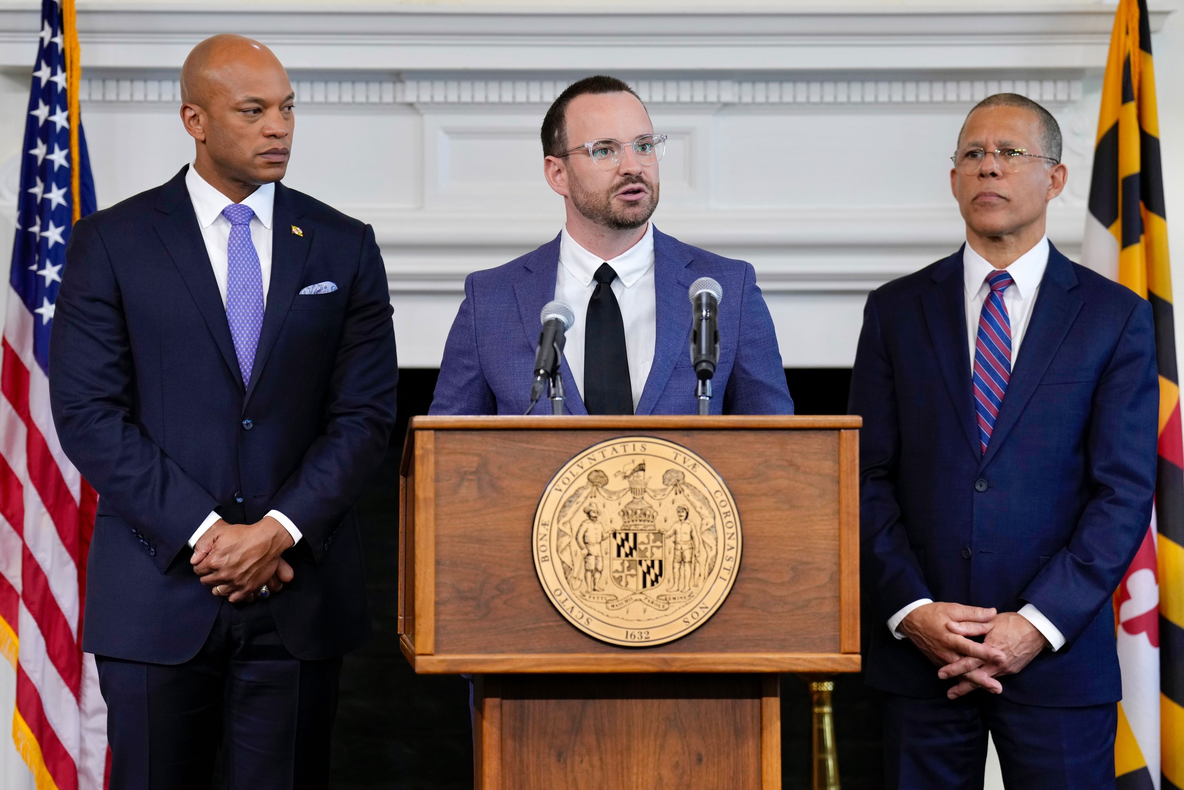 Dr. Jeff Kukucka, center, joined by Gov. Wes Moore and Attorney General Anthony Brown at a press conference at the State House in Annapolis to announce the release a wide-ranging independent audit of nearly 90 in-custody deaths spanning 2003 to 2019.