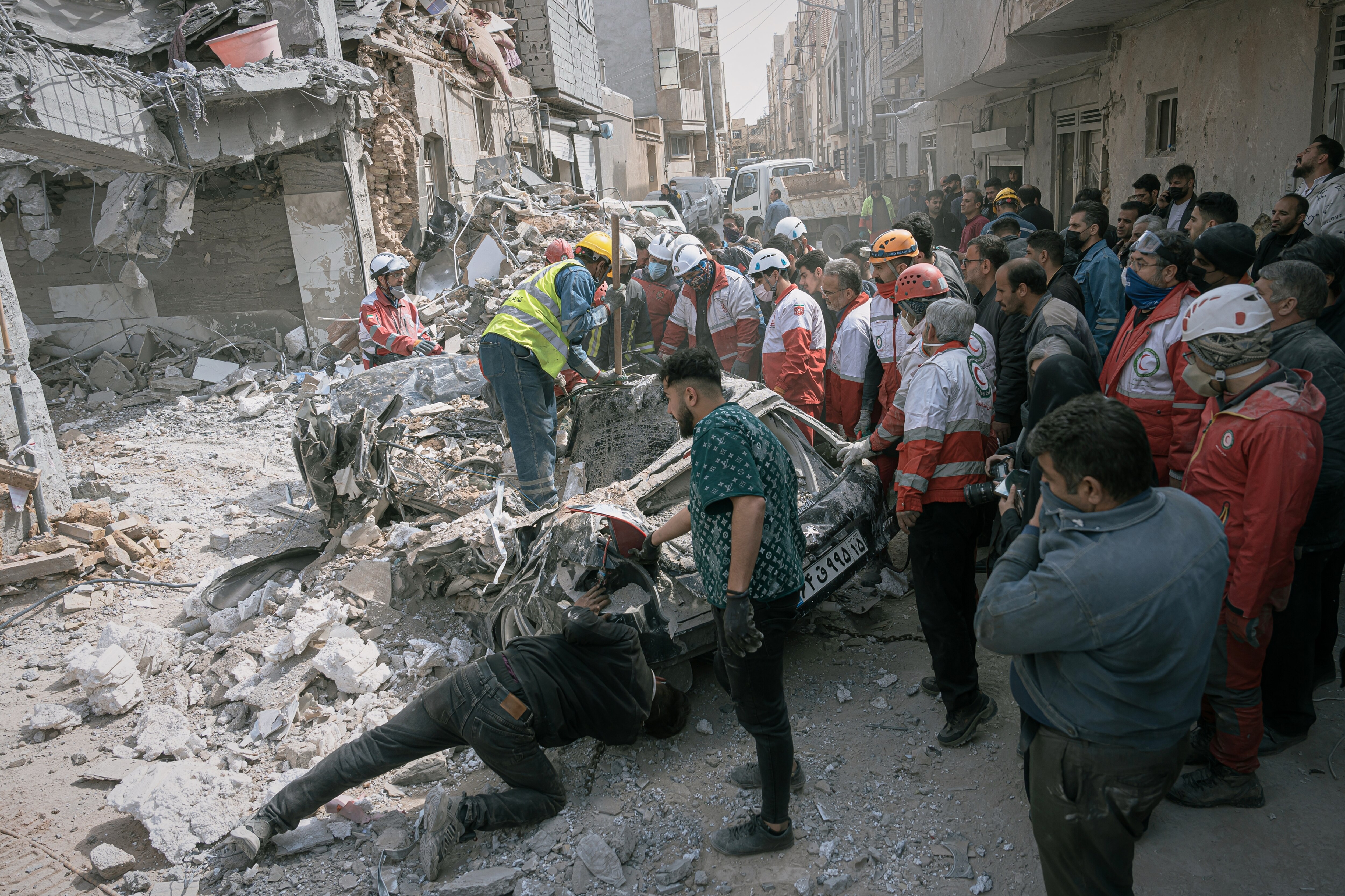 First responders inspect a destroyed car at the site of a residential building hit in an overnight strike in Tabriz, East Azerbaijan Province, northwestern Iran.