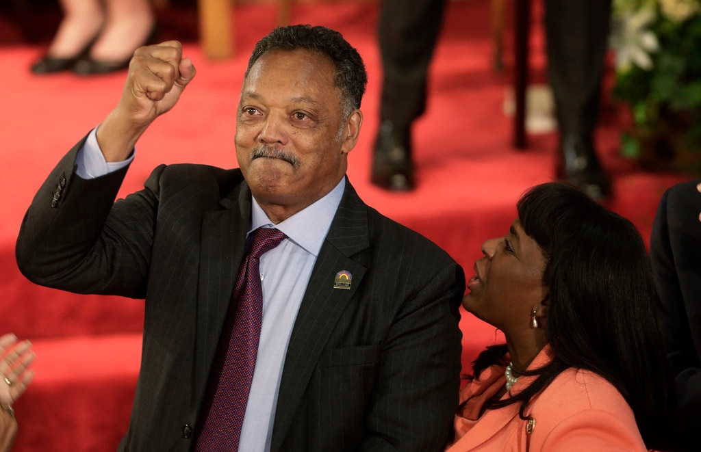 Rev. Jesse Jackson gestures to a friend in the balcony at the 16th Street Baptist Church in Birmingham, Alabama, Sept. 15, 2013. The church held a ceremony honoring the memory of the four young girls who were killed by a bomb placed outside the church 50 years ago by members of the Ku Klux Klan. At right is U.S. Rep. Terri Sewell, D-Ala.