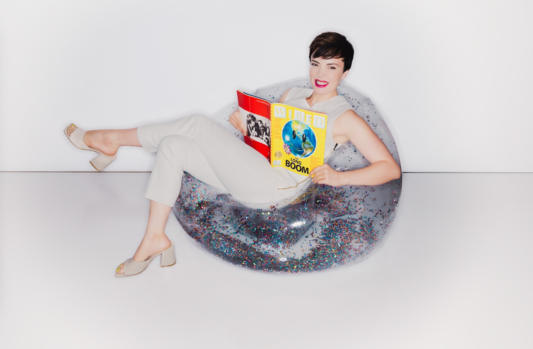 Local author Colette Shade poses with an issue of WIRED magazine in a funky, Y2K-style chair. Her book is a collections of essays that are a mashup of memoir and reportage.