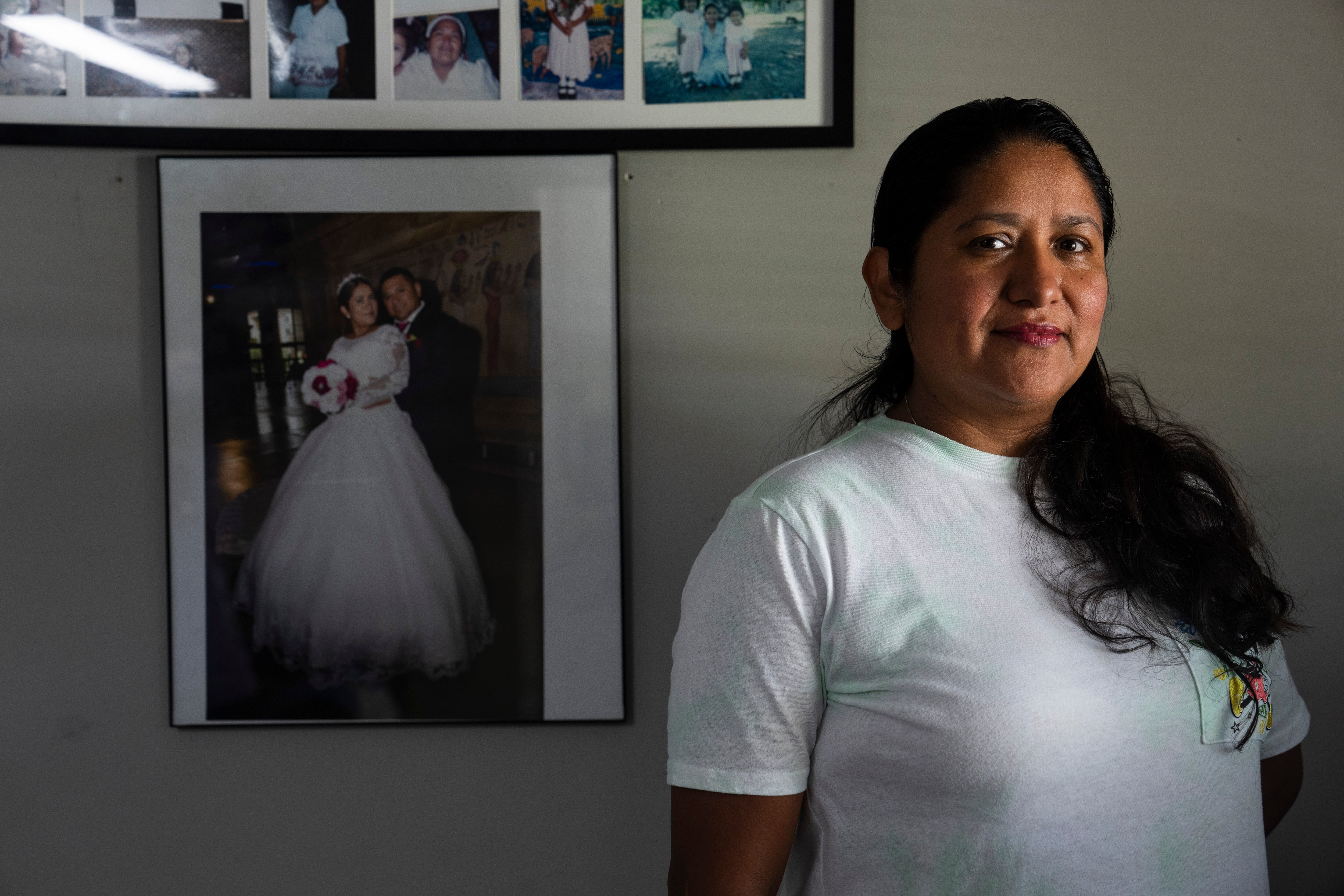 Maria del Carmen Castellon, wife of Miguel Luna, thinks about her late husband as a portrait of them on their wedding day hangs on the wall behind her.