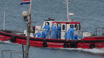 Health workers in protective gear arrive to evacuate patients from the MV Hondius cruise ship at a port in Praia, Cape Verde, Wednesday, May 6, 2026.