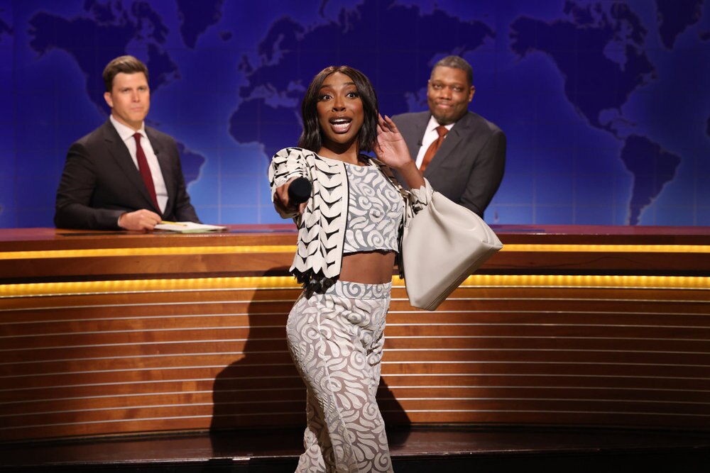 SATURDAY NIGHT LIVE -- Episode 1884 -- Pictured: (l-r) Anchor Colin Jost, Ego Nwodim as Miss Eggy, and anchor Michael Che during Weekend Update on Saturday, May 17, 2025 -- (Photo by: Will Heath/NBC)