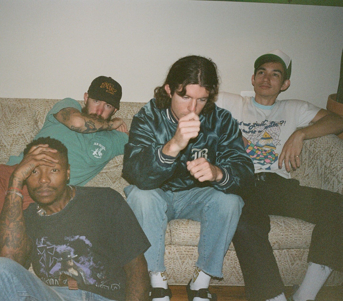 The Baltimore hardcore band Turnstile is pictured sitting on a couch.