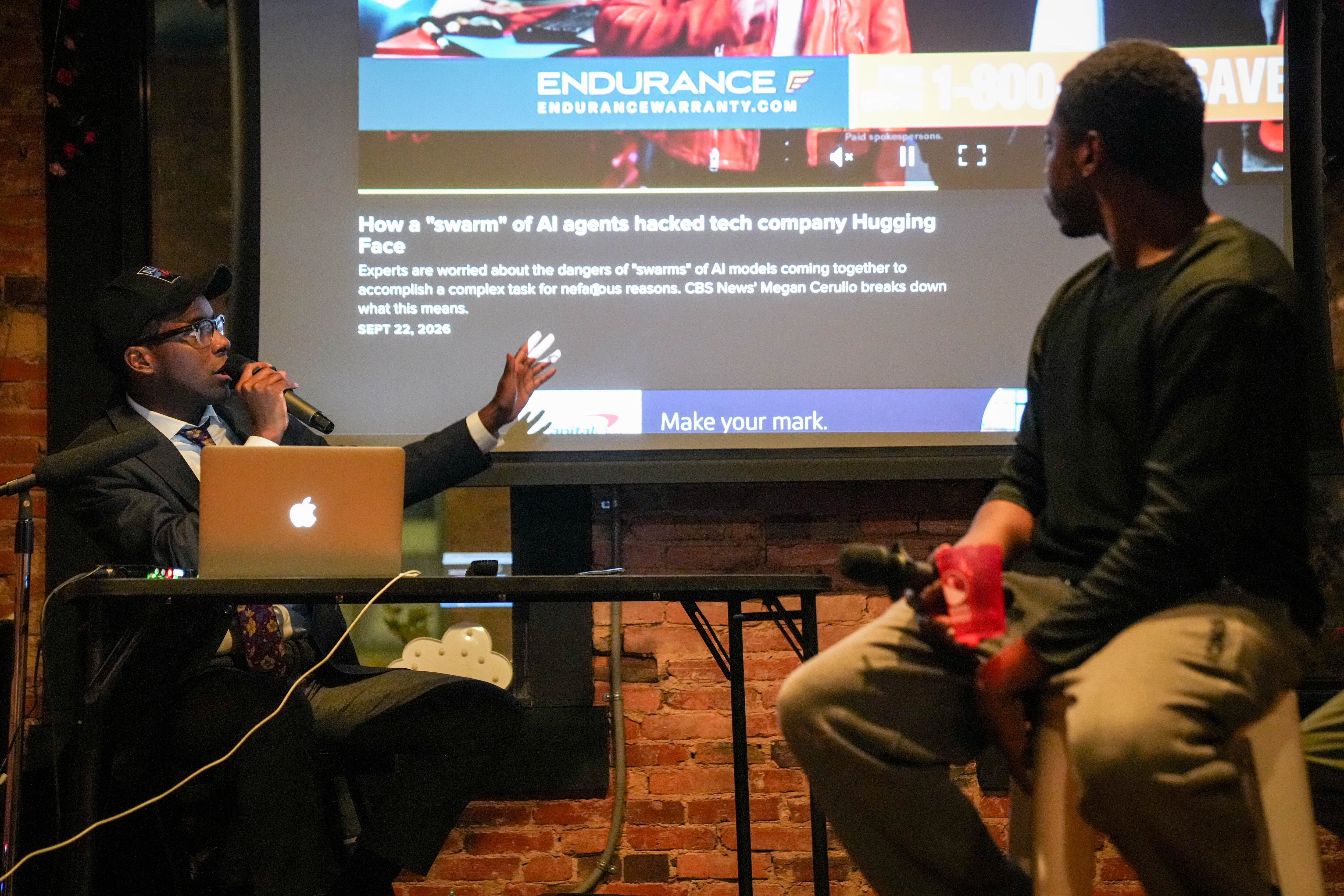 Cameron Smith, left, host of The Droconomist, introduces a news article for a panel of comedians.