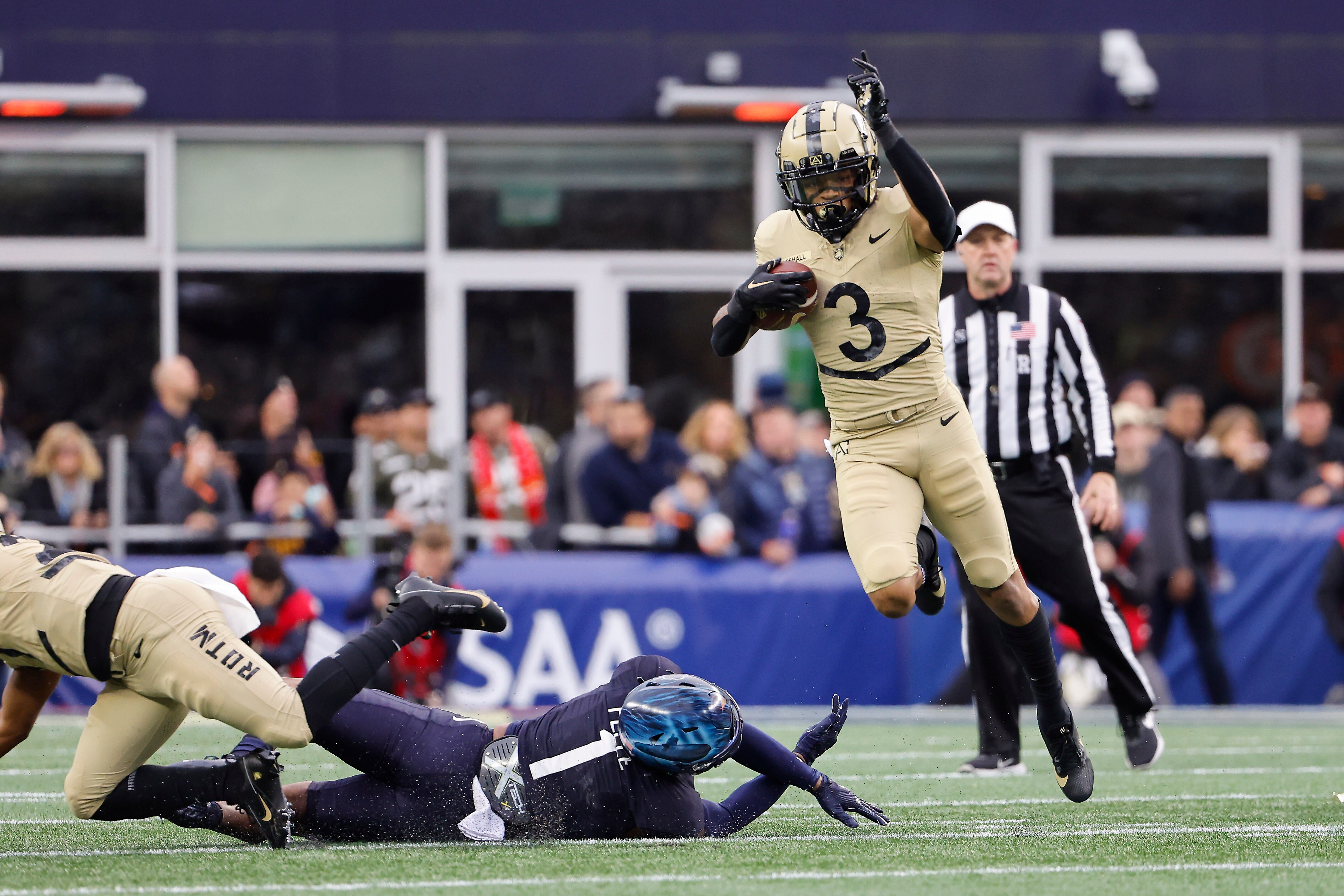 Army's Ay'Jaun Marshall leaps over Navy's Dashaun Peele during the first quarter of the Cadets' 17-11 win Saturday in Foxborough, Massachusetts.