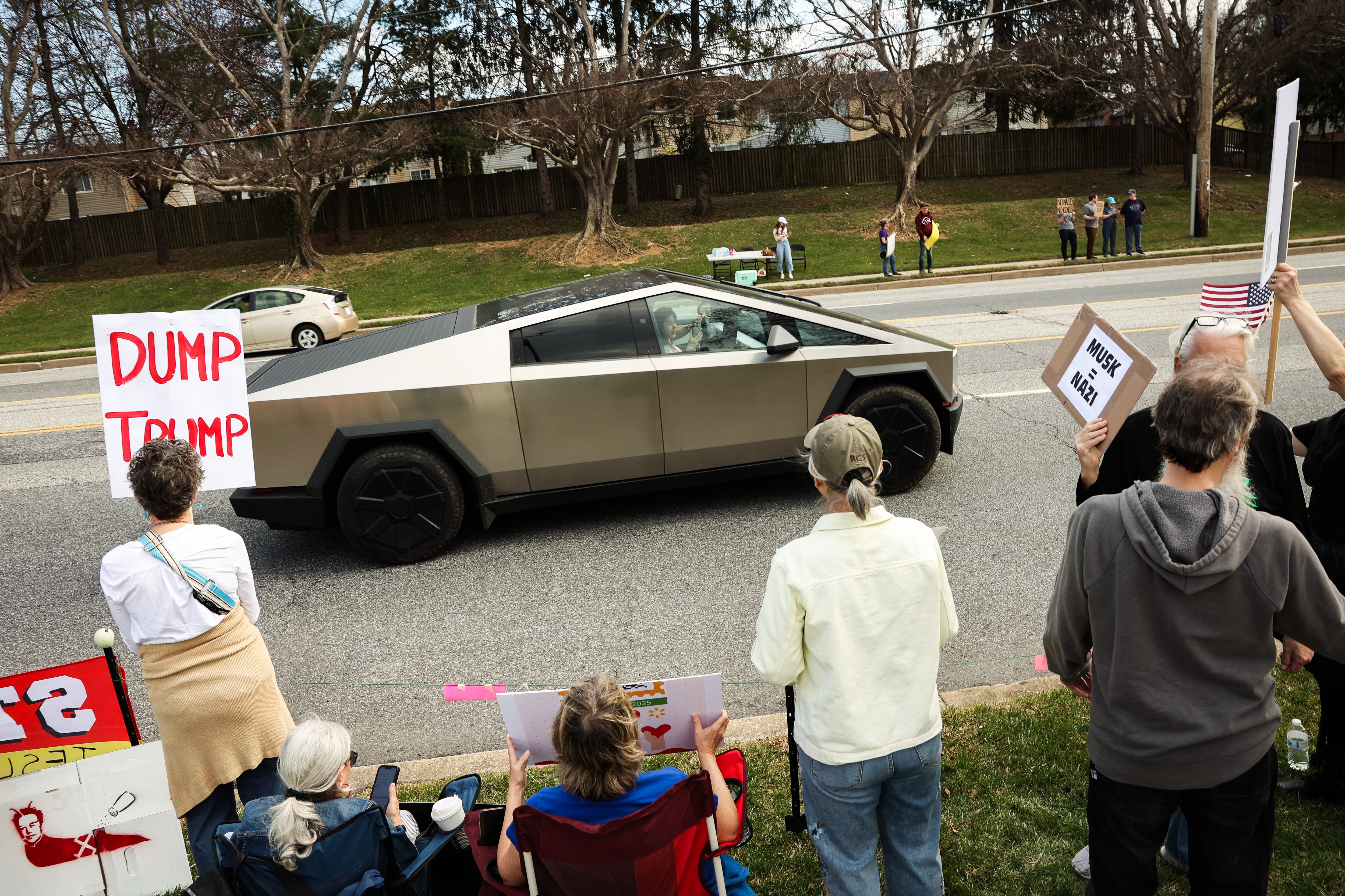 Hundreds of protesters gather in front of a Tesla dealership in Owings Mills on Saturday, March 29, 2025, to protest Elon Musk and the DOGE government cuts.