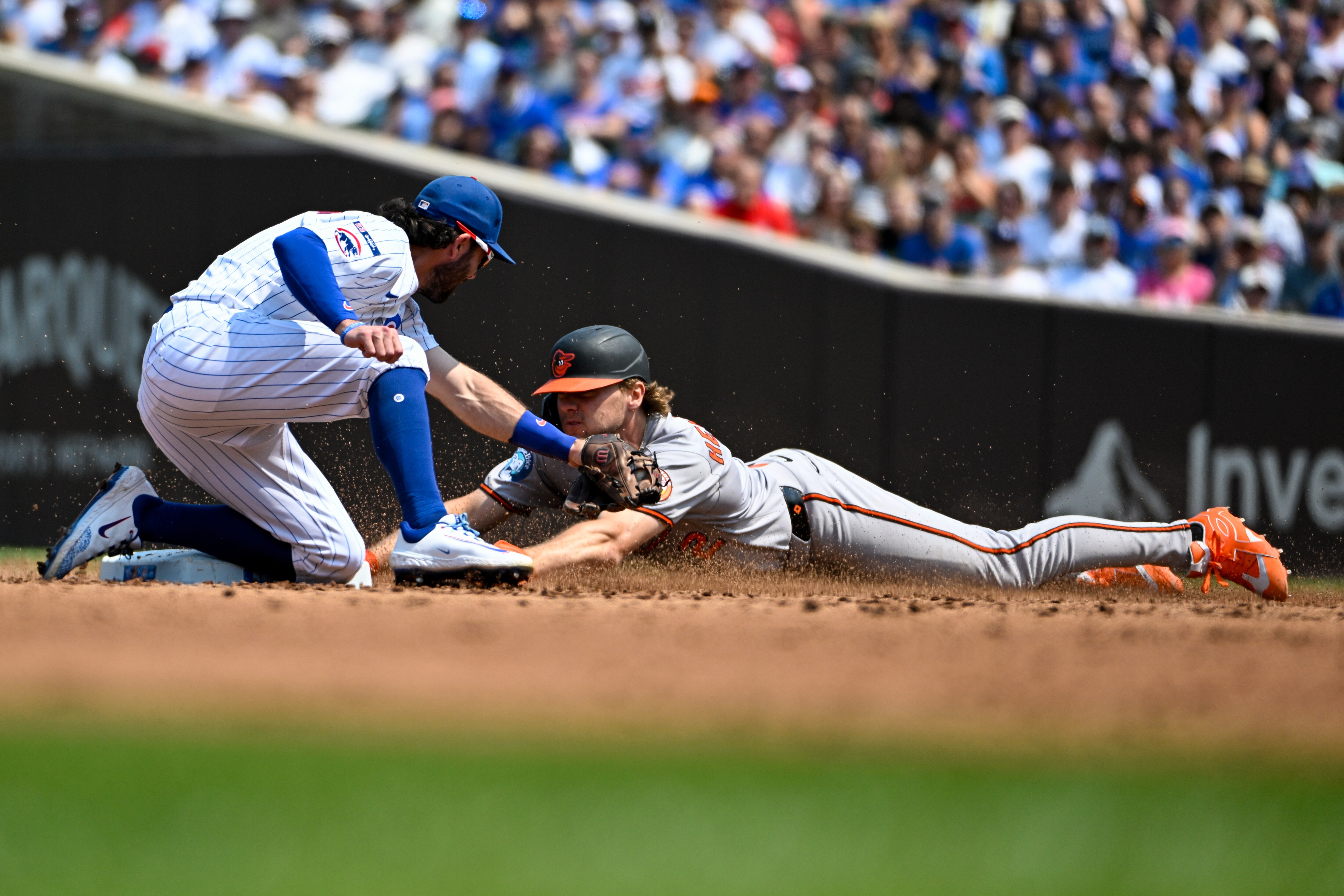 Dansby Swanson of the Cubs tags out Gunnar Henderson attempting to steal in the third inning.