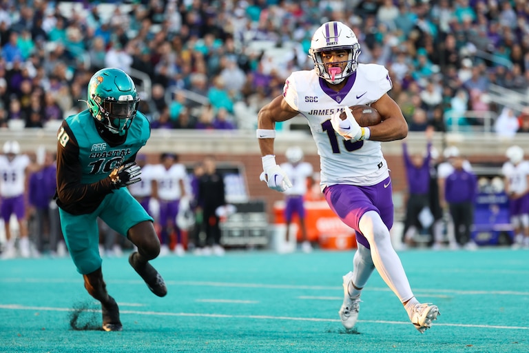 Elijah Sarratt (13) of the James Madison Dukes runs the ball for a touchdown against Abraham Temoney III (19) of the Coastal Carolina Chanticleers at Brooks Stadium on November 25, 2023 in Conway, South Carolina.