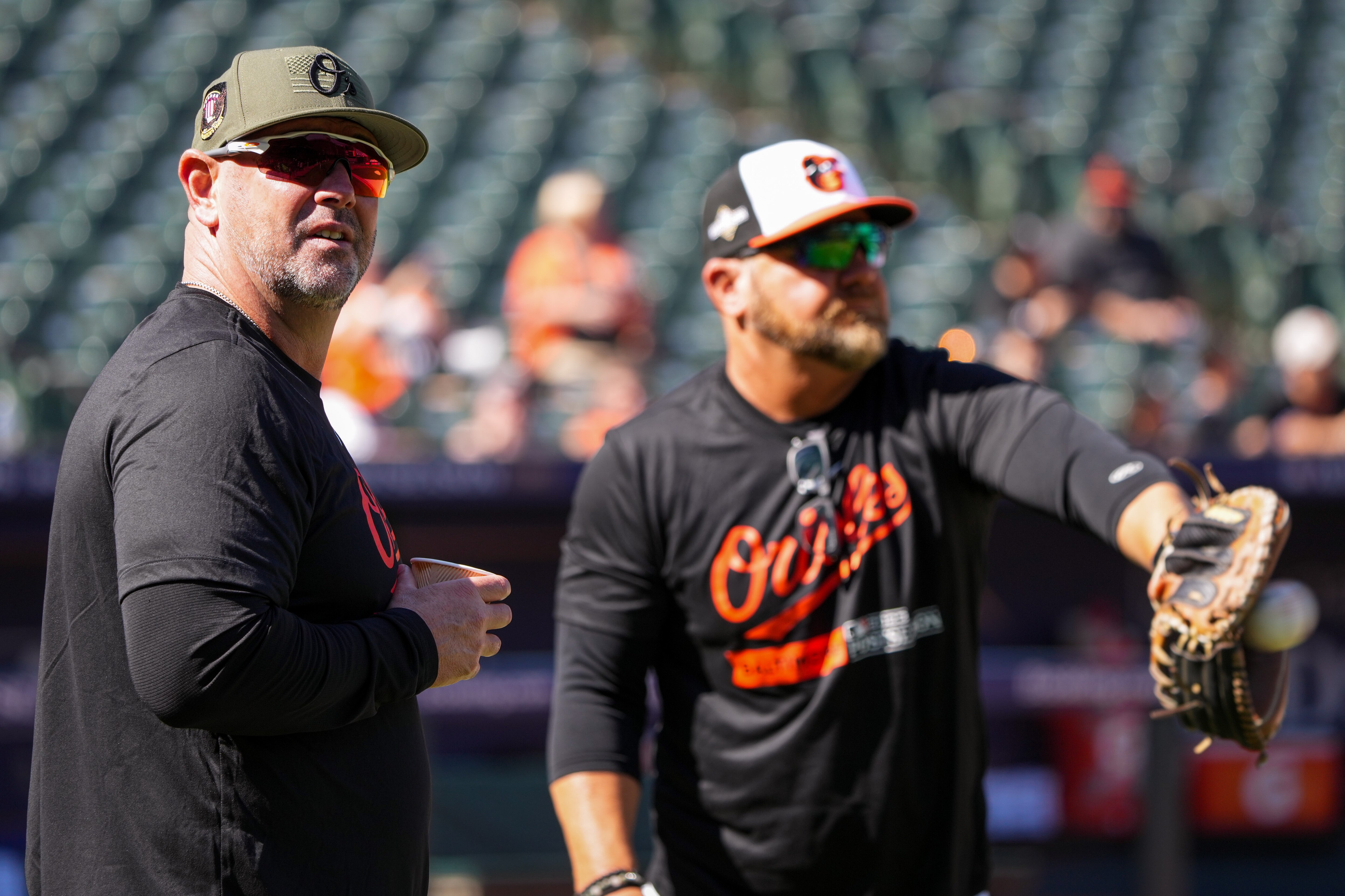 Orioles manager Brandon Hyde, left, and field coordinator Tim Cossins observe an open practice at Camden Yards on Wednesday in preparation for ALDS Game 1 on Saturday against the Texas Rangers.