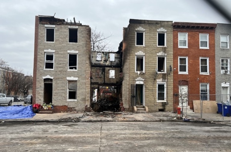 A gap between homes in the 200 block of S. Stricker St. marks the spot where a vacant home burned and collapsed, killing three Baltimore firefighters.