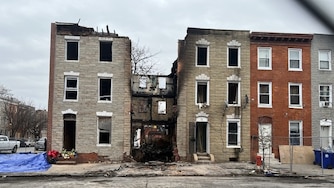 A gap between homes in the 200 block of S. Stricker St. marks the spot where a vacant home burned and collapsed, killing three Baltimore firefighters.