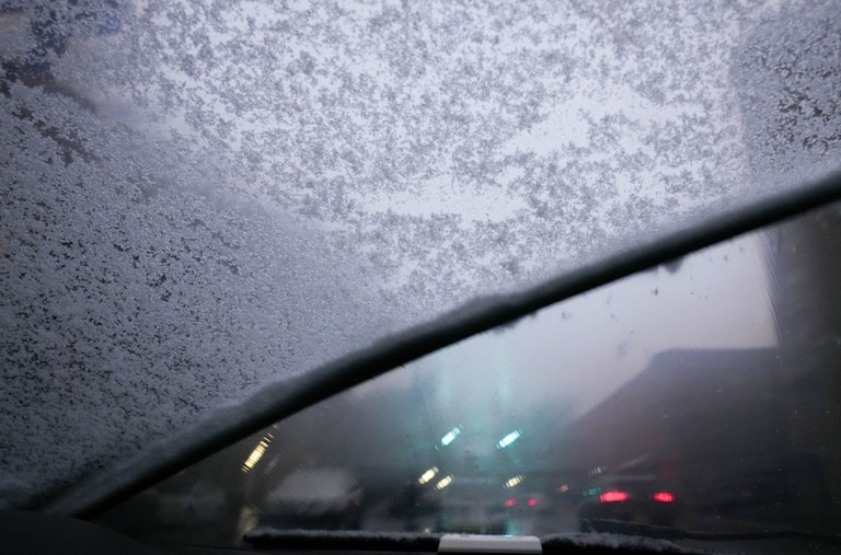 Windshield wipers brush aside a layer of ice that collected on a snowy evening in Baltimore, Md. on Tuesday, February 11, 2025.
