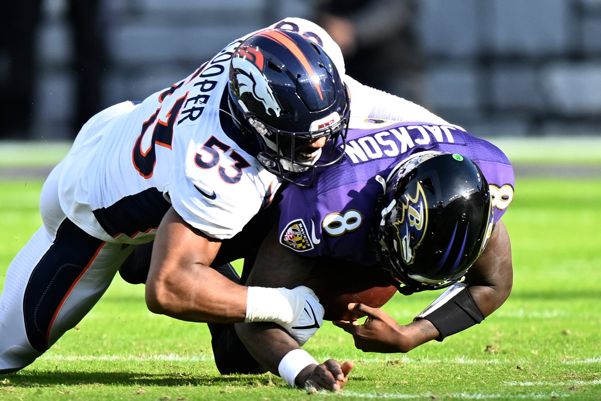 BALTIMORE, MARYLAND - DECEMBER 04: Jonathon Cooper #53 of the Denver Broncos sacks Lamar Jackson #8 of the Baltimore Ravens in the first half at M&T Bank Stadium on December 04, 2022 in Baltimore, Maryland.