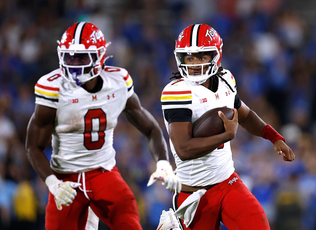 Maryland quarterback Malik Washington follows the block of running back DeJuan Williams.