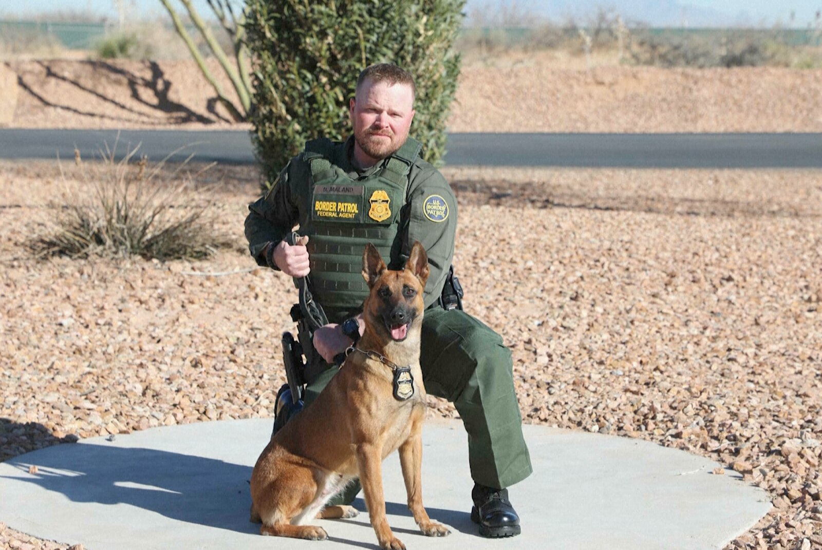 U.S. Border Patrol Agent David Maland posing with a service dog.