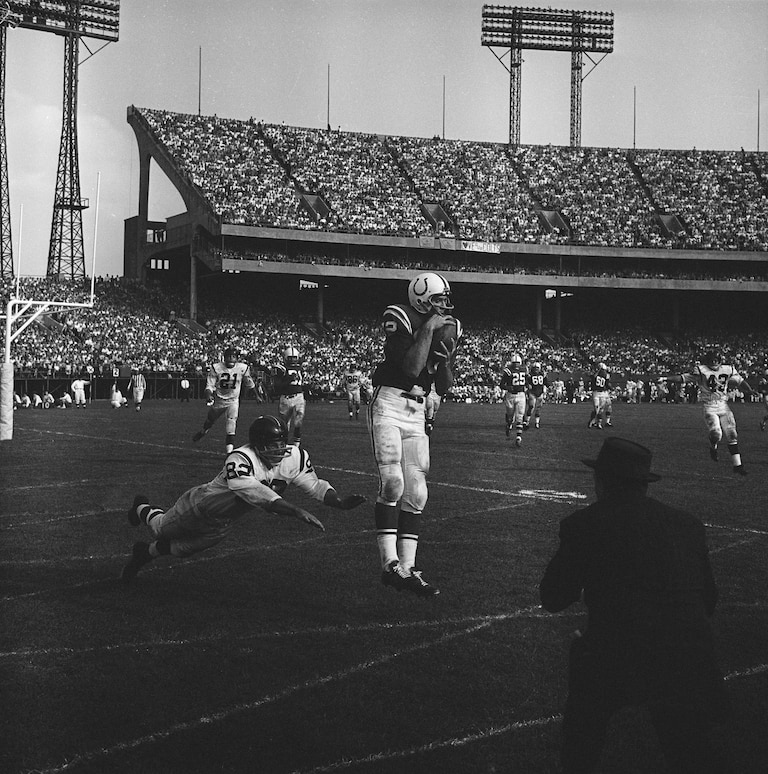 Baltimore Colts end Raymond Berry catches a 13-yard touchdown pass thrown by quarterback Johnny Unitas on Sept. 25, 1960.
