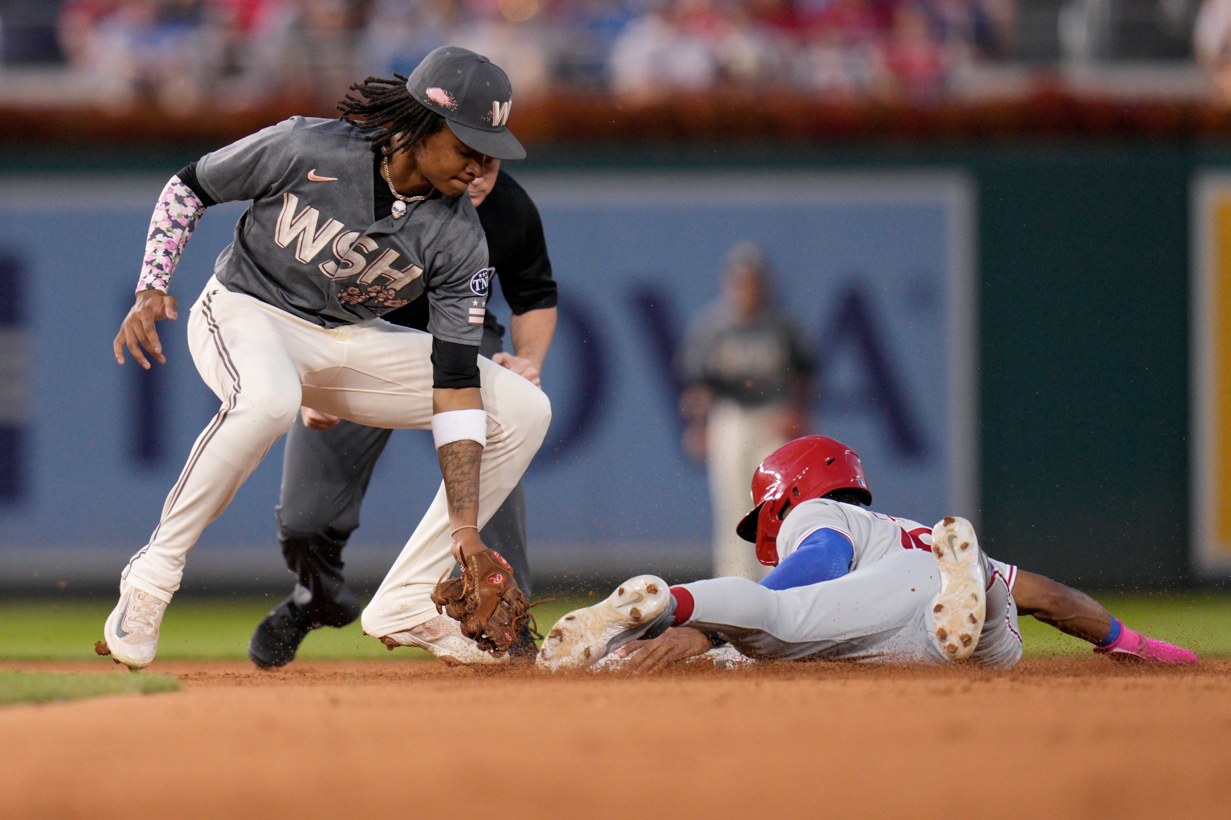 Johan Rojas of the Phillies beats the tag of Nationals shortstop CJ Abrams to steal second in the fourth inning of Washington's 8-7 victory Friday night.