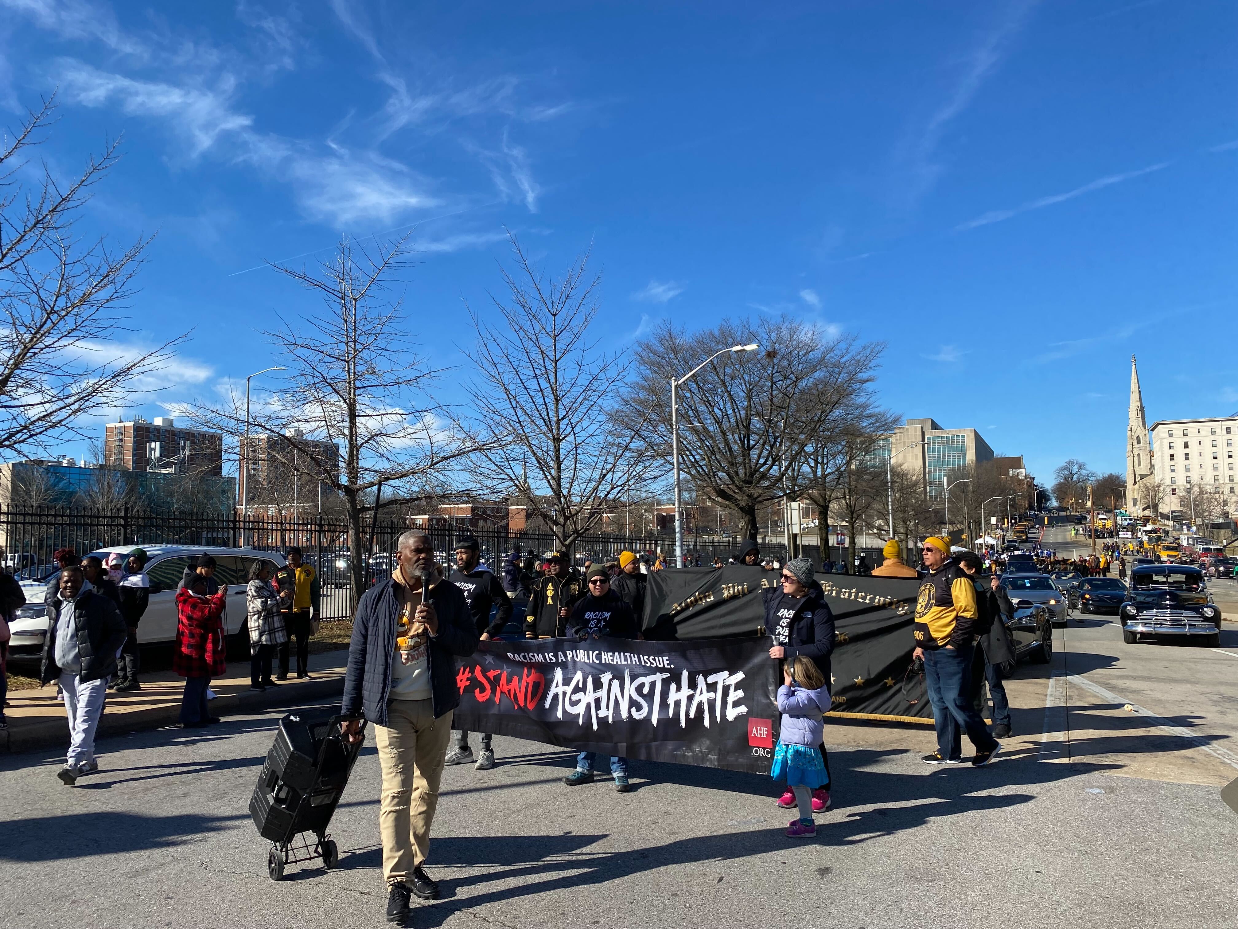 Marchers hold a sign showing their solidarity against hate at Baltimore's MLK Day parade on Jan. 16, 2023.