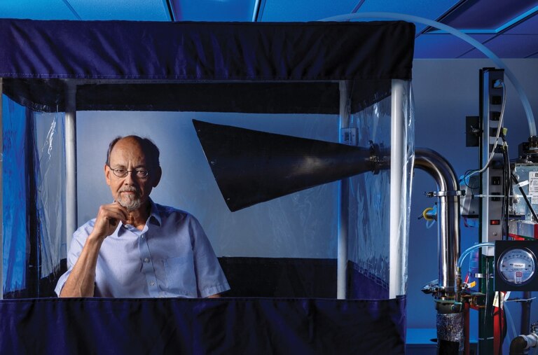 Dr. Don Milton sits in a Gesundheit machine, which he helped develop to capture and analyze infectious viruses in the breath of people who are sick.